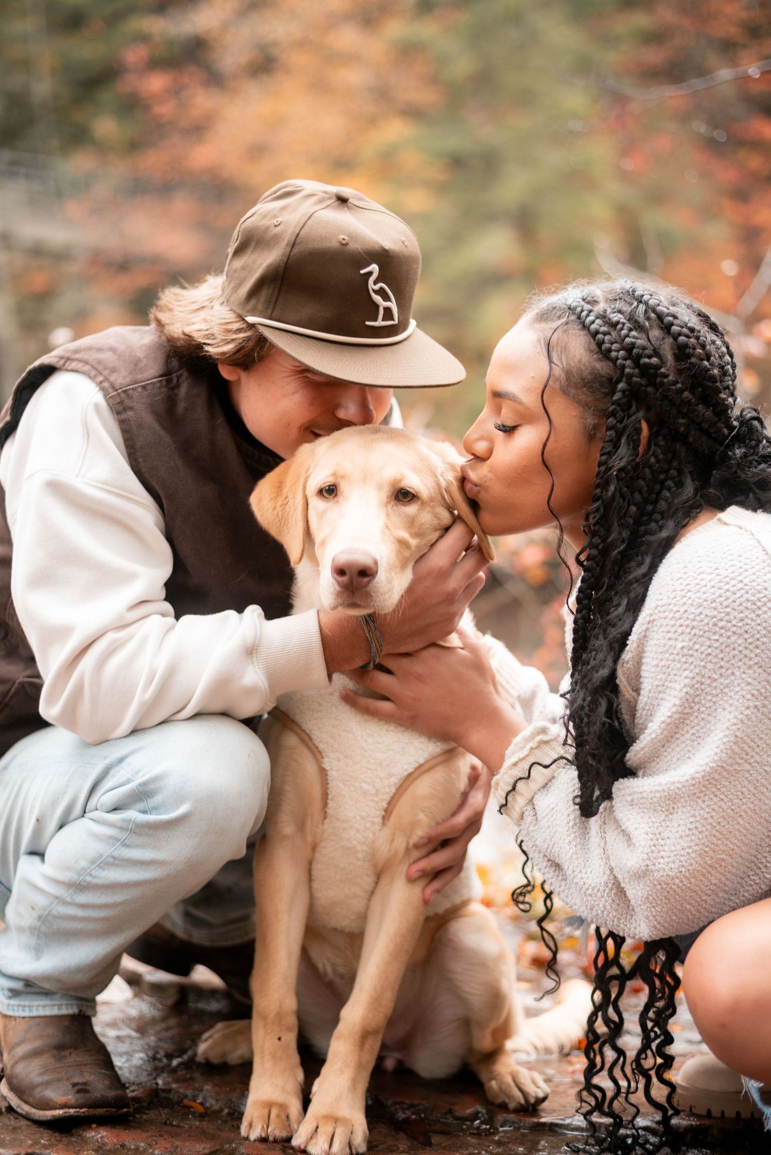 A couple shares sweet moments with their yellow Labrador puppy in autumn.