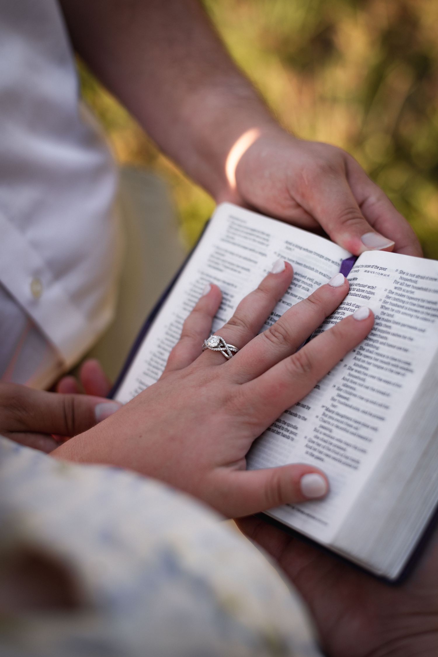 Close-up series of hands holding an open book showing an engagement ring.