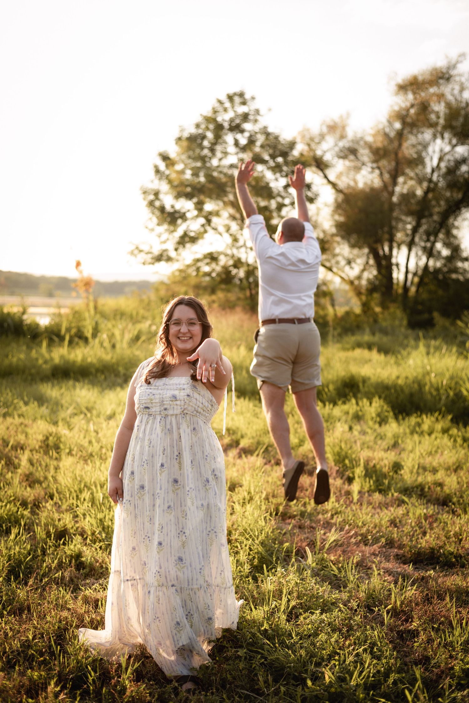 Playful moments captured in a sunny field with flowing white dress.