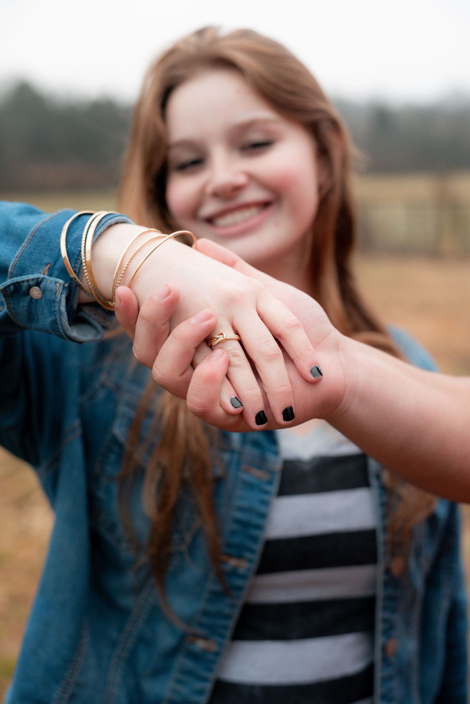 Close up of hands with black nail polish showing affection and joy.
