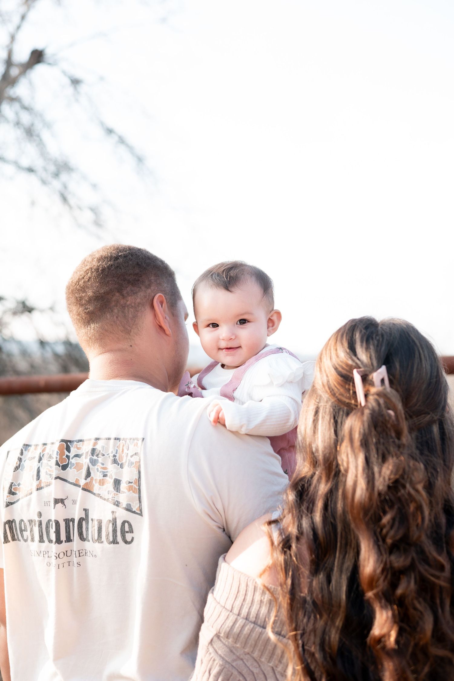Family enjoying a tender moment together outdoors in warm evening light.