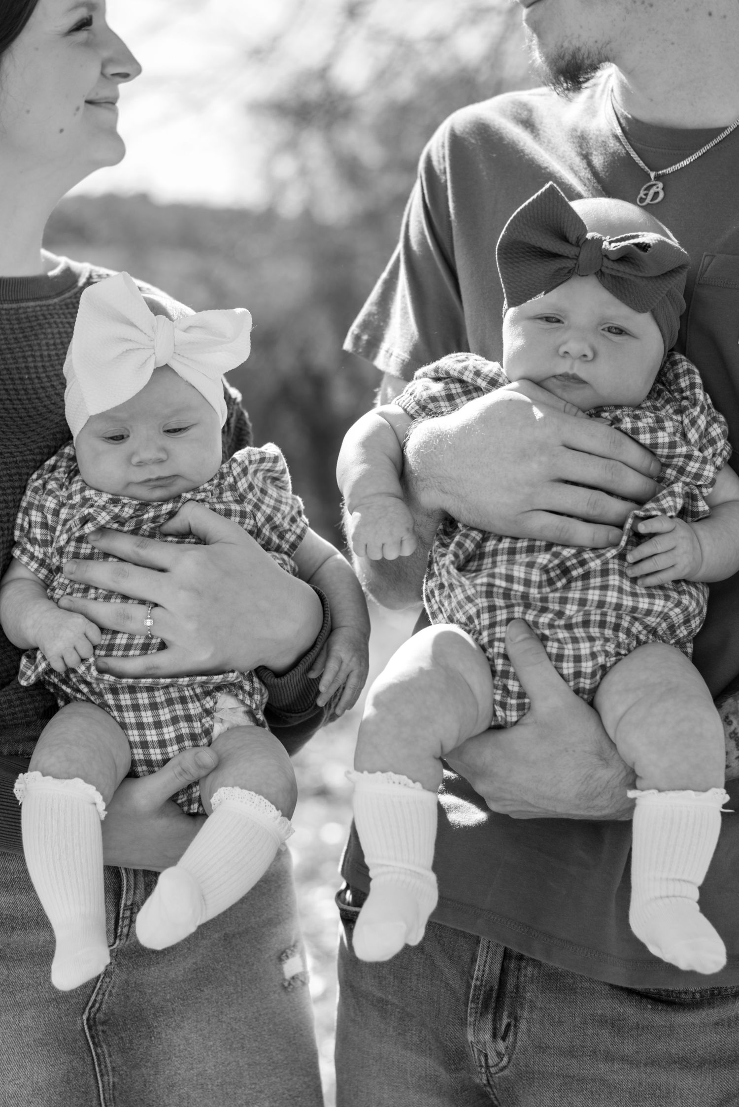 Black and white series showing baby in checkered outfit being held.