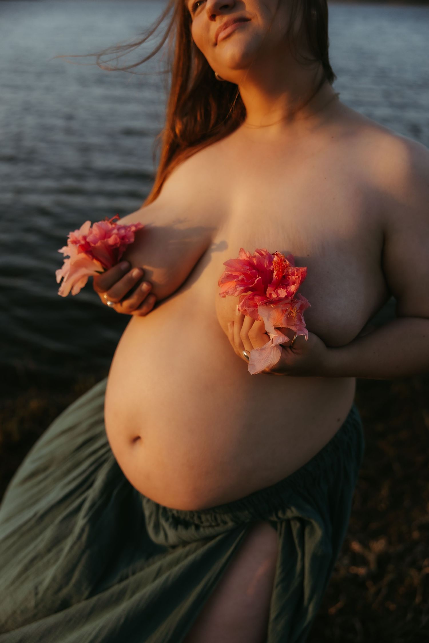 maternity with flowers
Pregnant woman holding flowers to her chest during an artistic maternity photoshoot by the water.