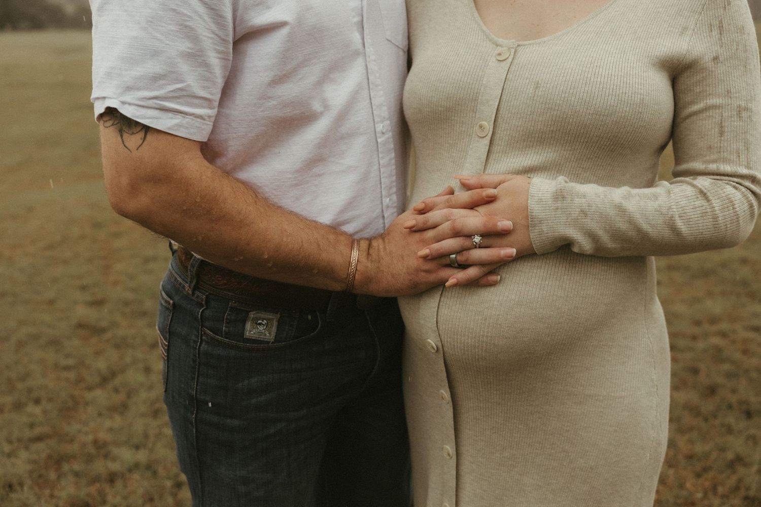 Hands on pregnant belly (two different sets of hands)
Family hands resting on a pregnant belly during a warm, intimate maternity session in