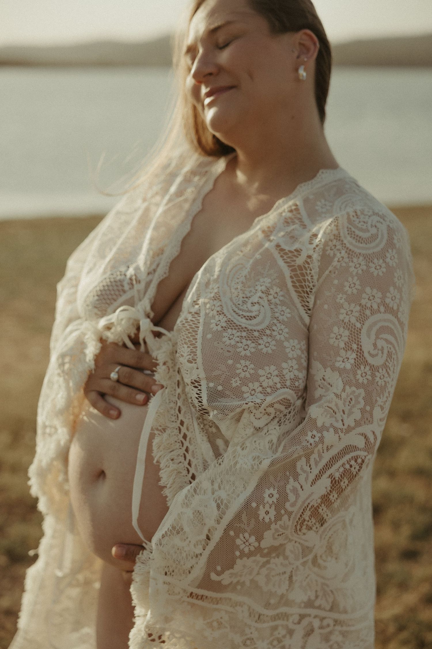 Pregnant woman smiling in lace dress
Smiling pregnant woman in lace gown during a natural maternity photoshoot by the water in Wivenhoe