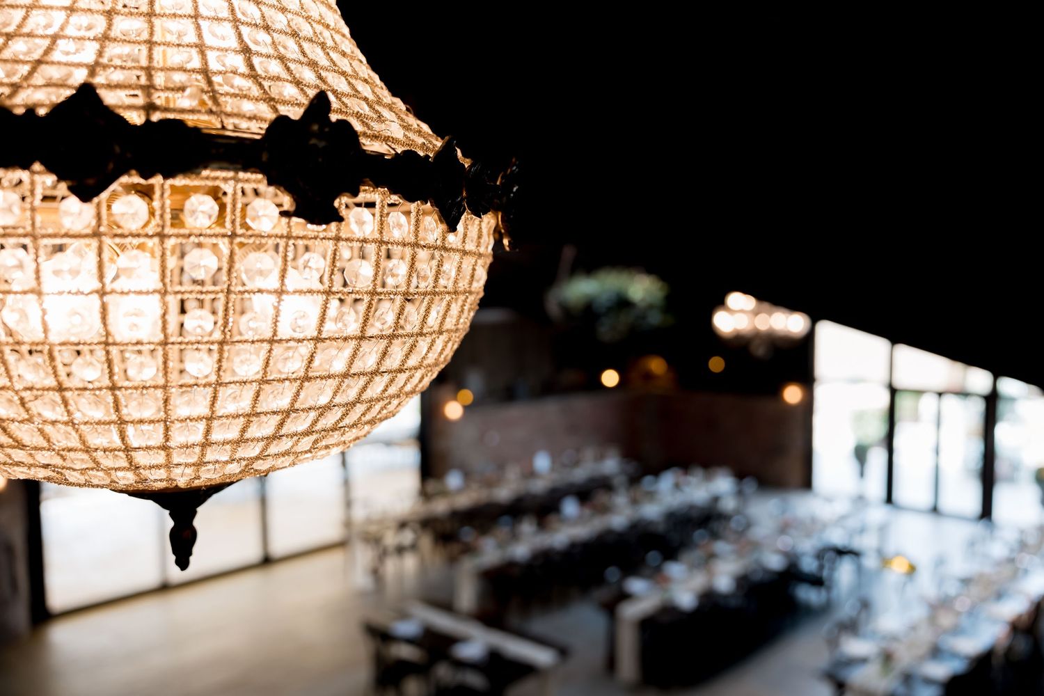 Elegant paper lanterns illuminate a wedding reception venue with warm ambient lighting.
