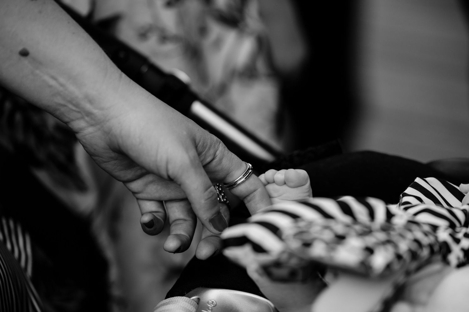 Black and white detail shot of hands during wedding reception.
