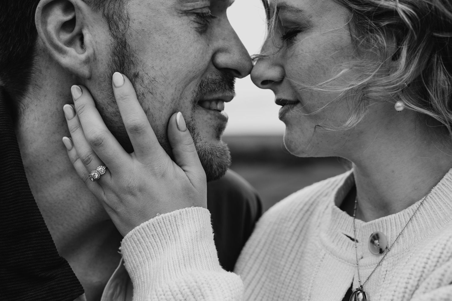 A tender black and white romantic moment captured against a natural backdrop.