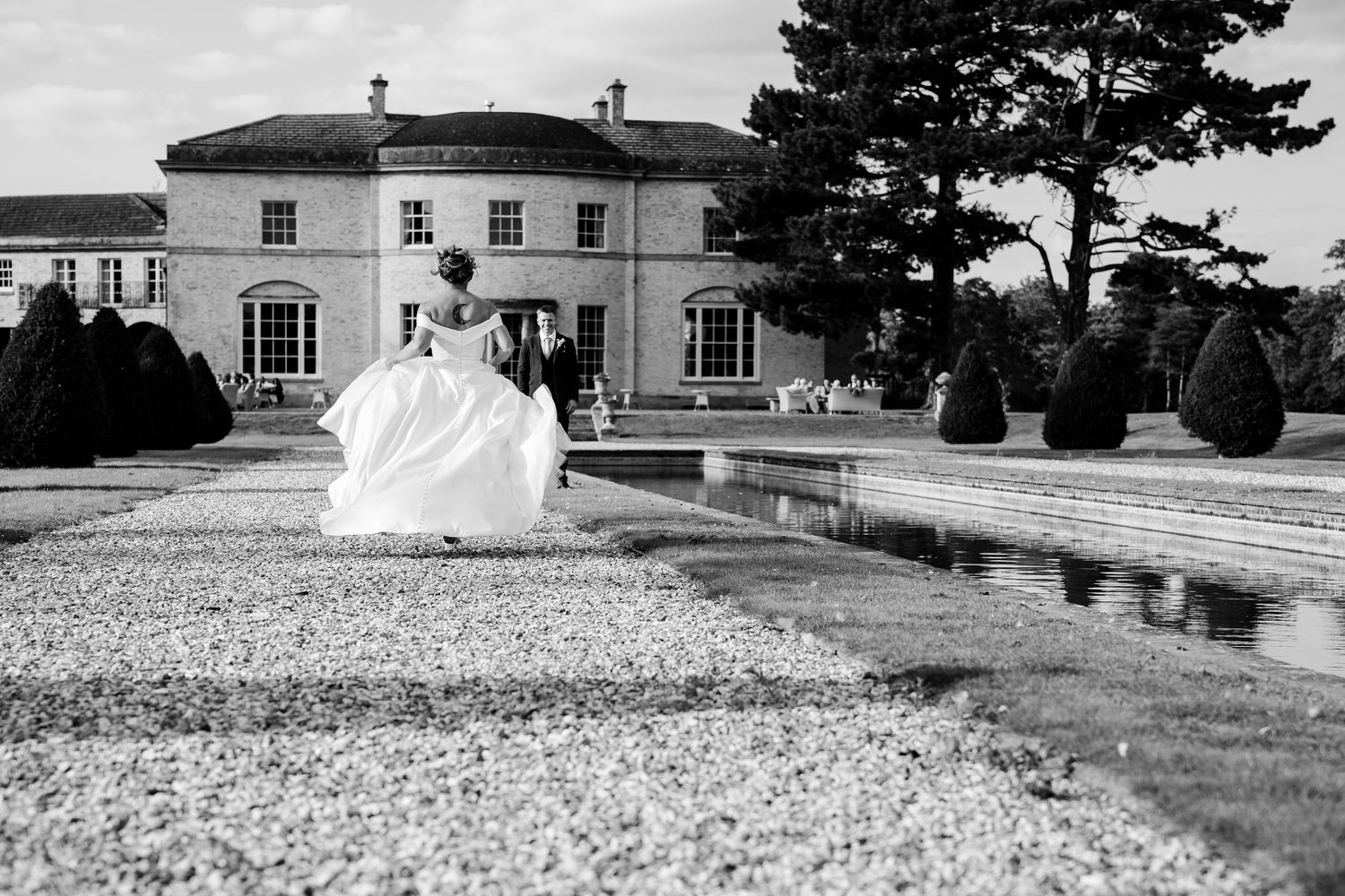 Black and white panoramic view of a historic estate with manicured gardens and architectural features.