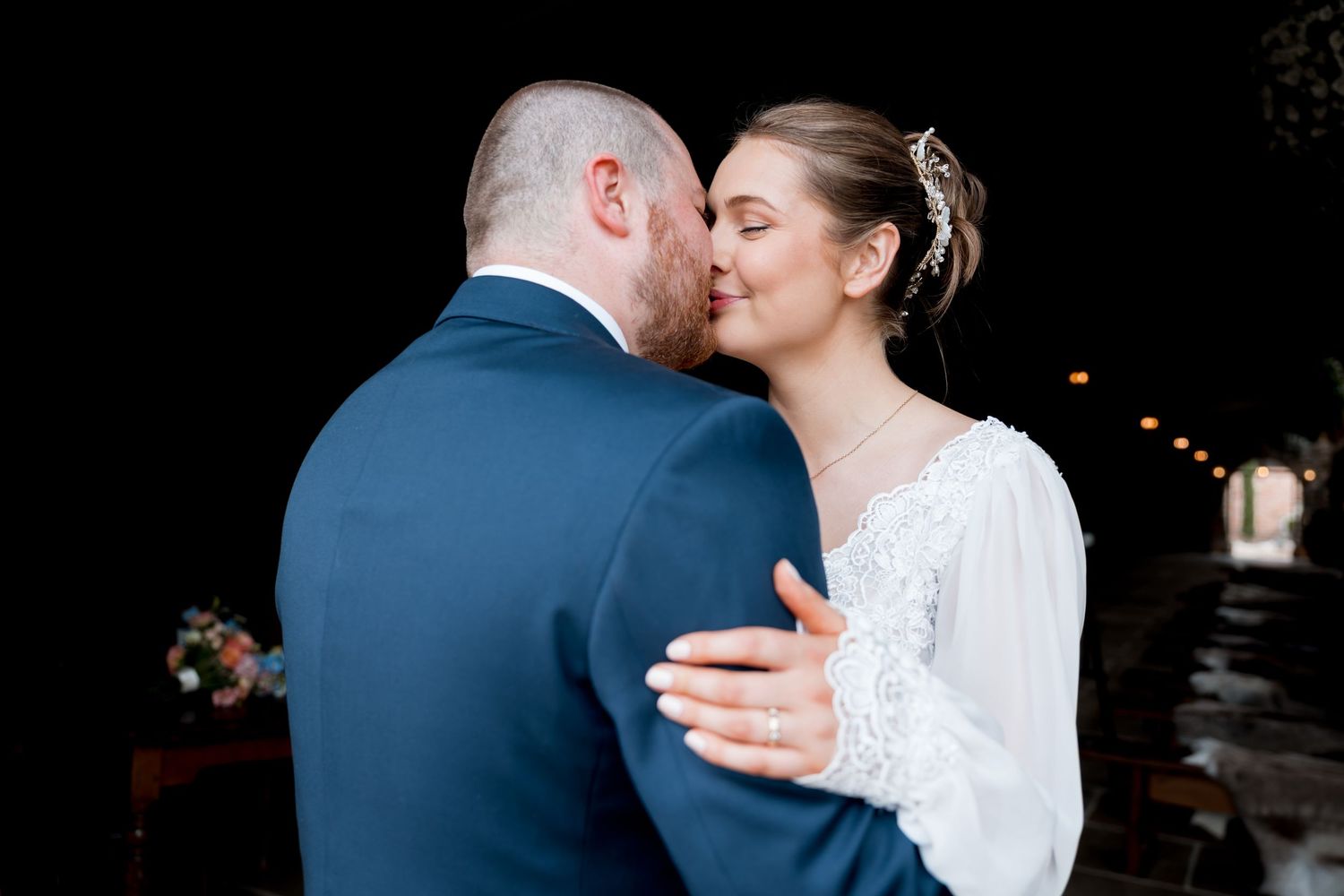 Intimate wedding dance moment captured against dark background.