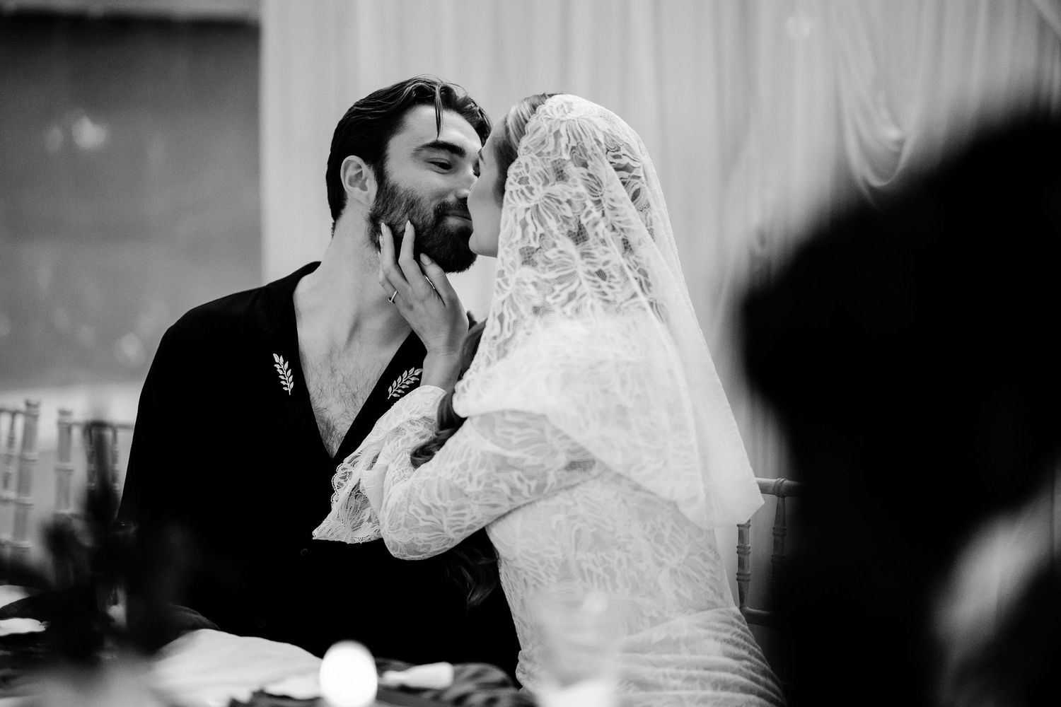 Artistic black and white wedding portrait showing a tender moment between newlyweds.