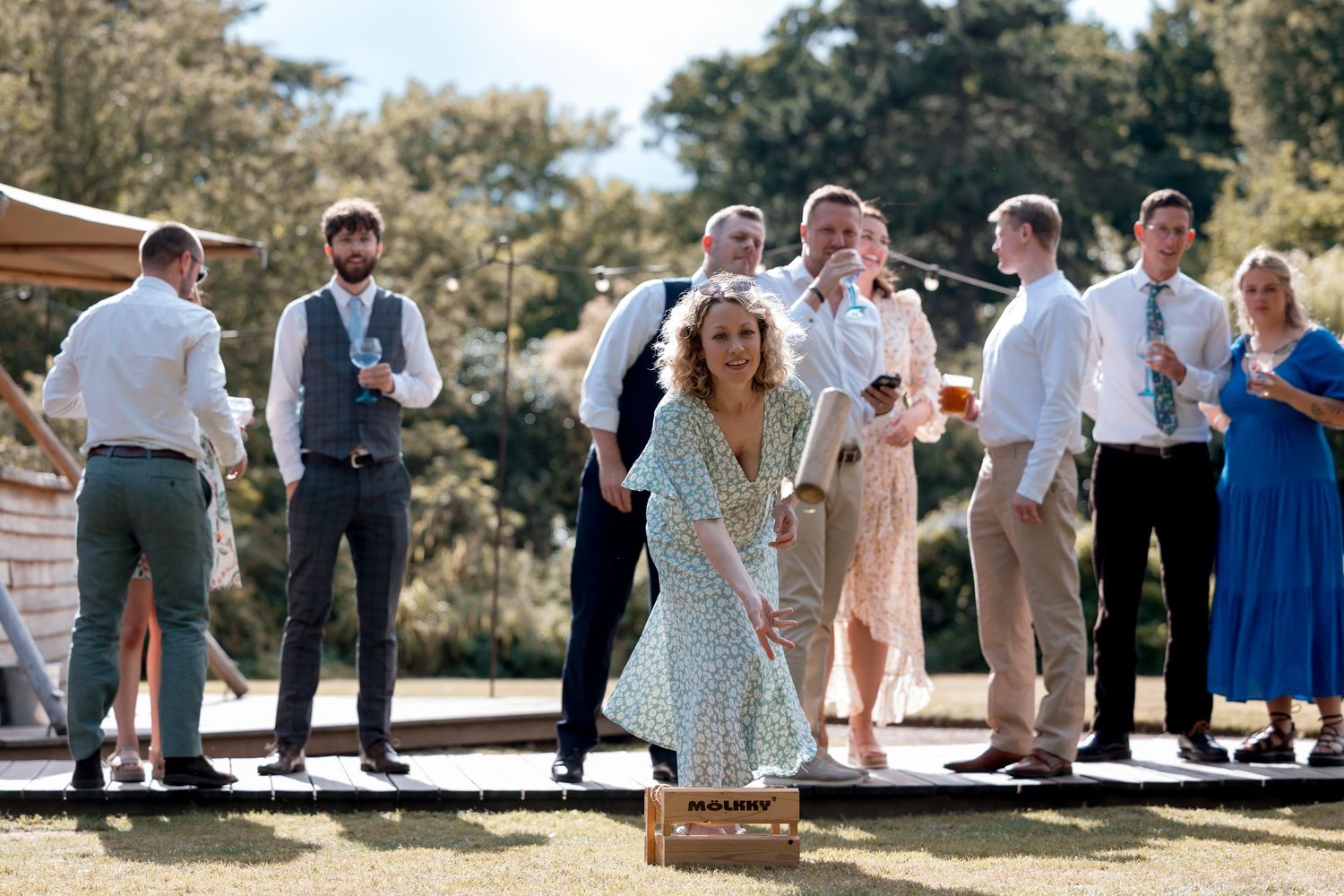 Wedding celebration with guests mingling on a sunny outdoor patio.