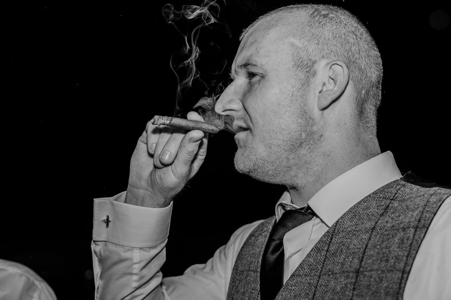 Black and white photo of wedding guests toasting with drinks at a celebration.