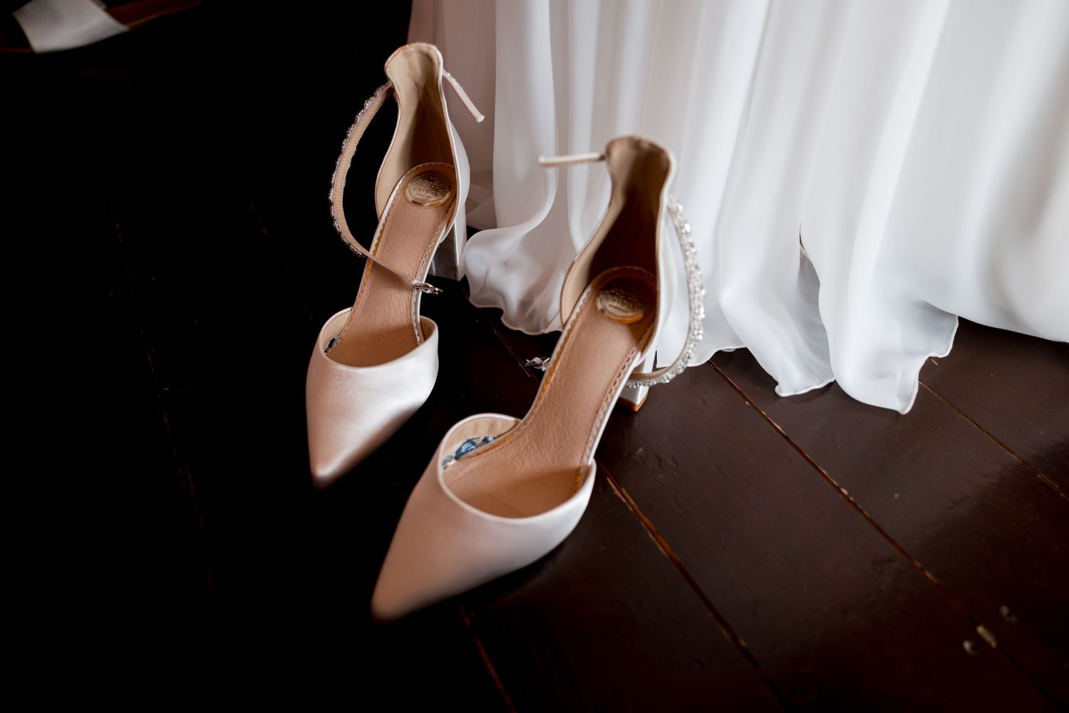 Wedding dress and shoes artistically arranged in natural light.