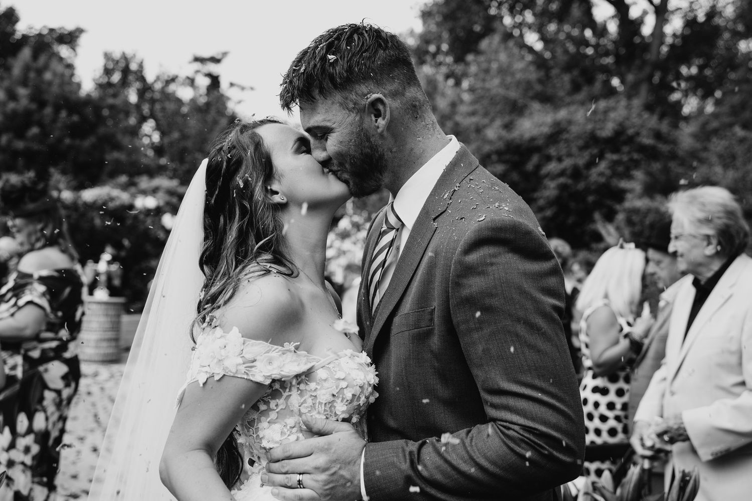 A series of black and white wedding photos showing romantic moments between a couple during their outdoor celebration.