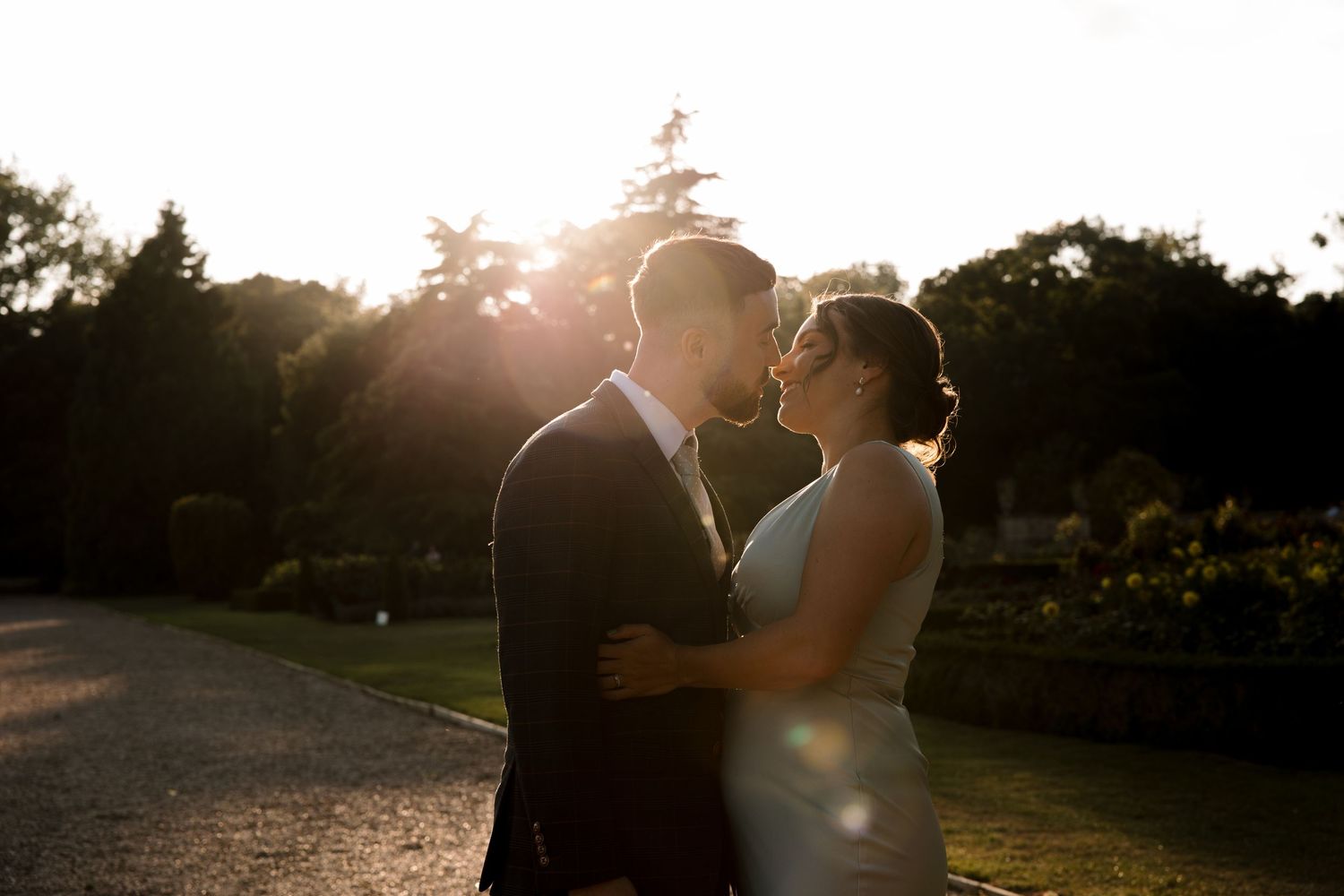 Silhouetted wedding couple embracing during a golden sunset photoshoot.
