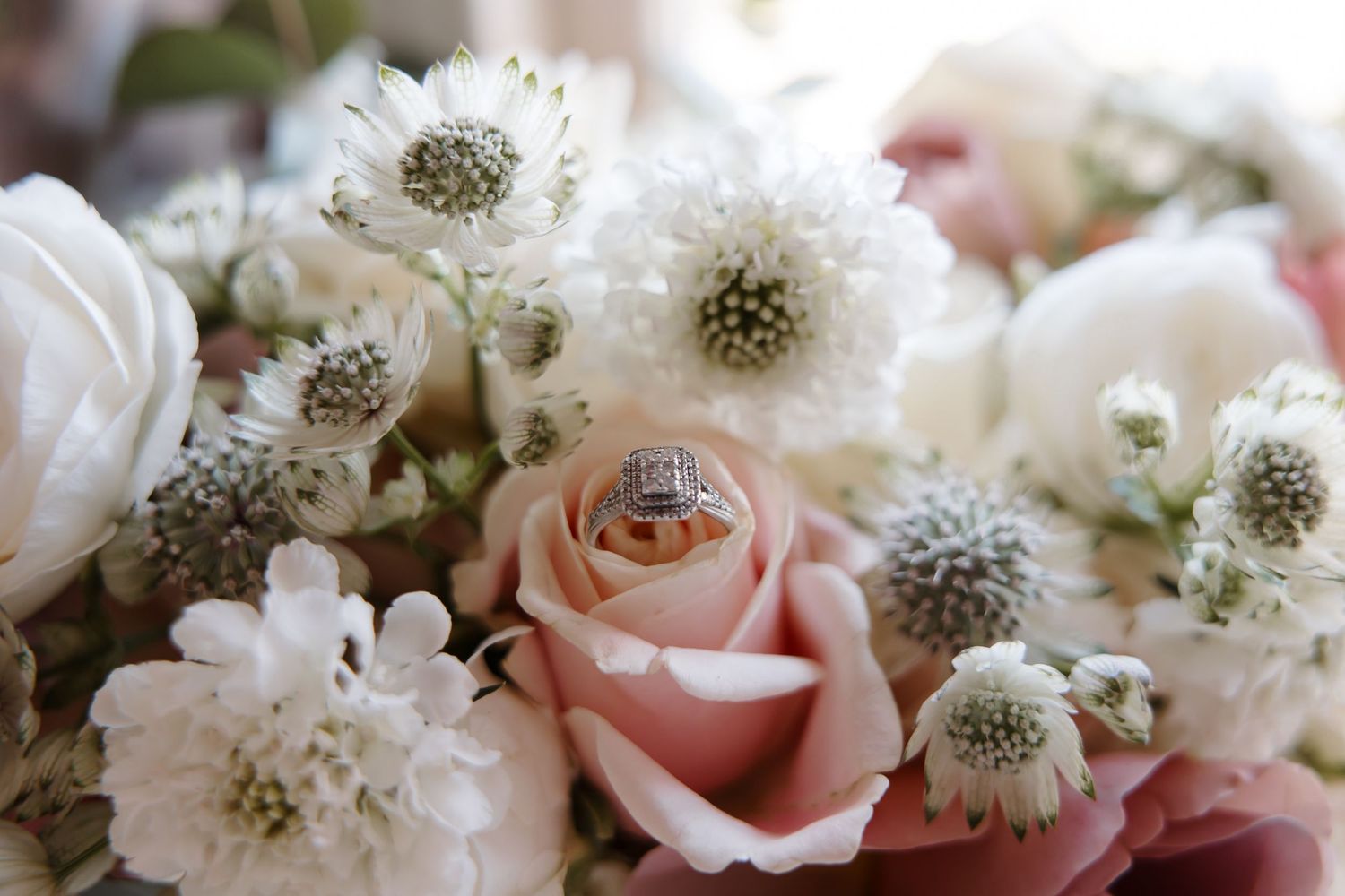 Elegant white and pink wedding flowers arranged with roses and small delicate blooms.