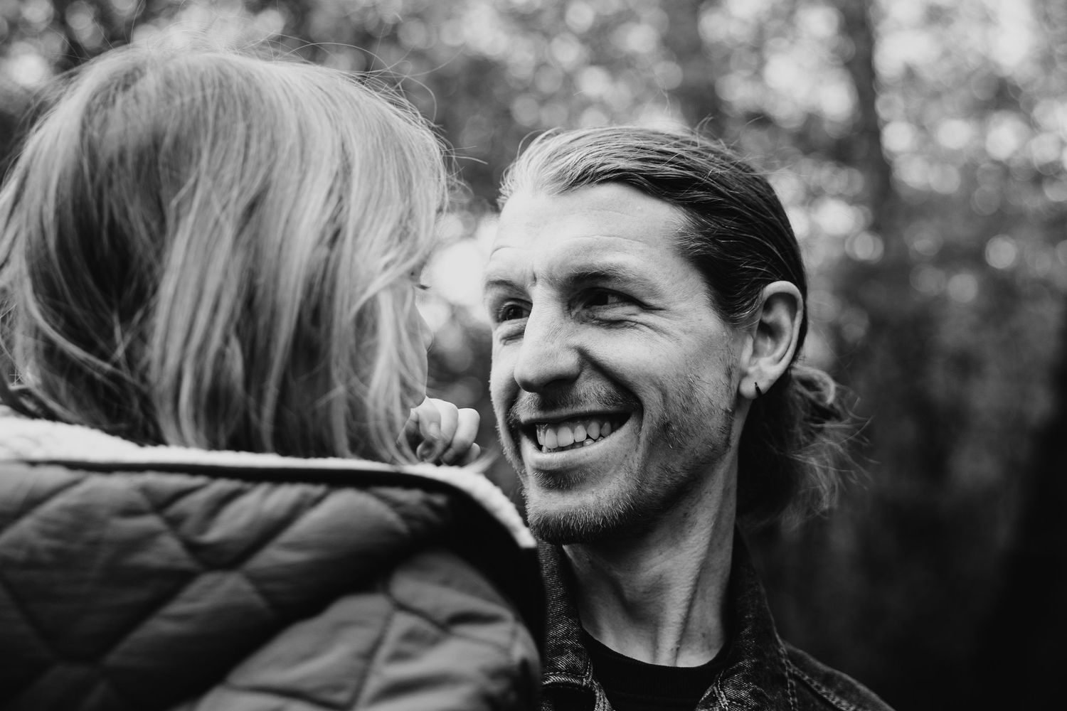 Candid black and white outdoor portrait series showing joyful moments.