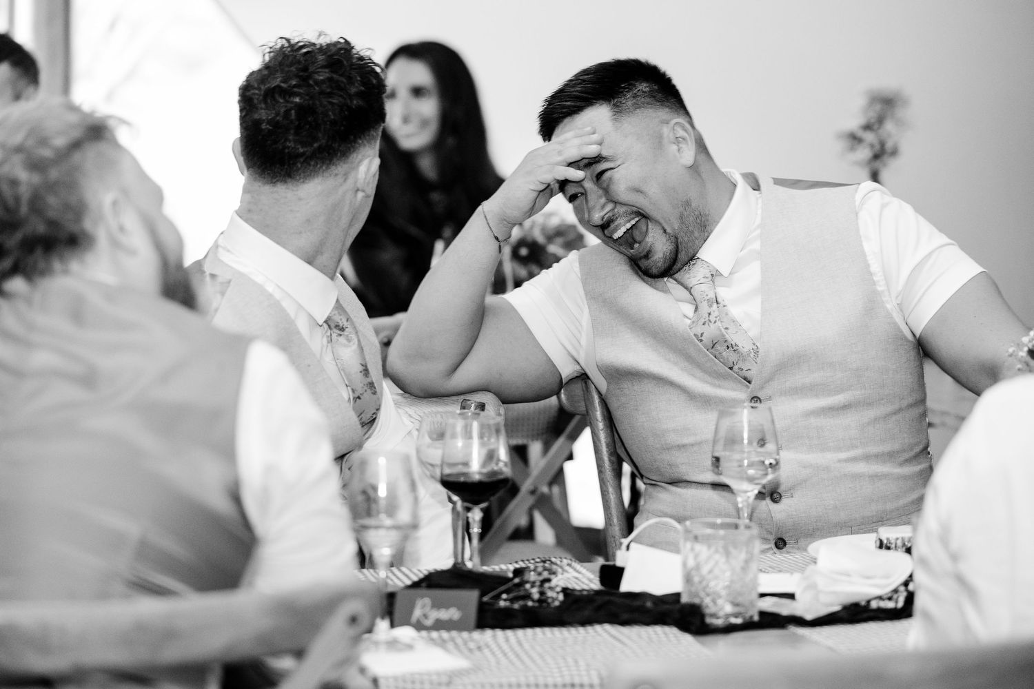 Black and white candid shots of wedding reception guests enjoying dinner and conversation.