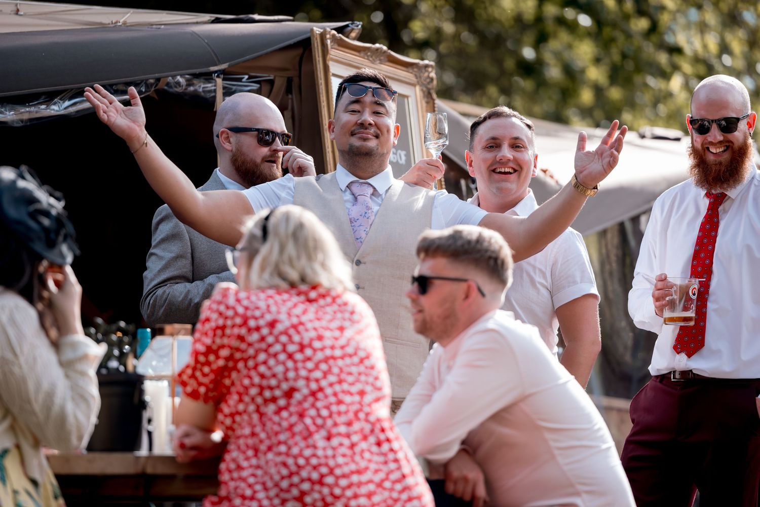 Wedding guests dance and celebrate at an outdoor reception.