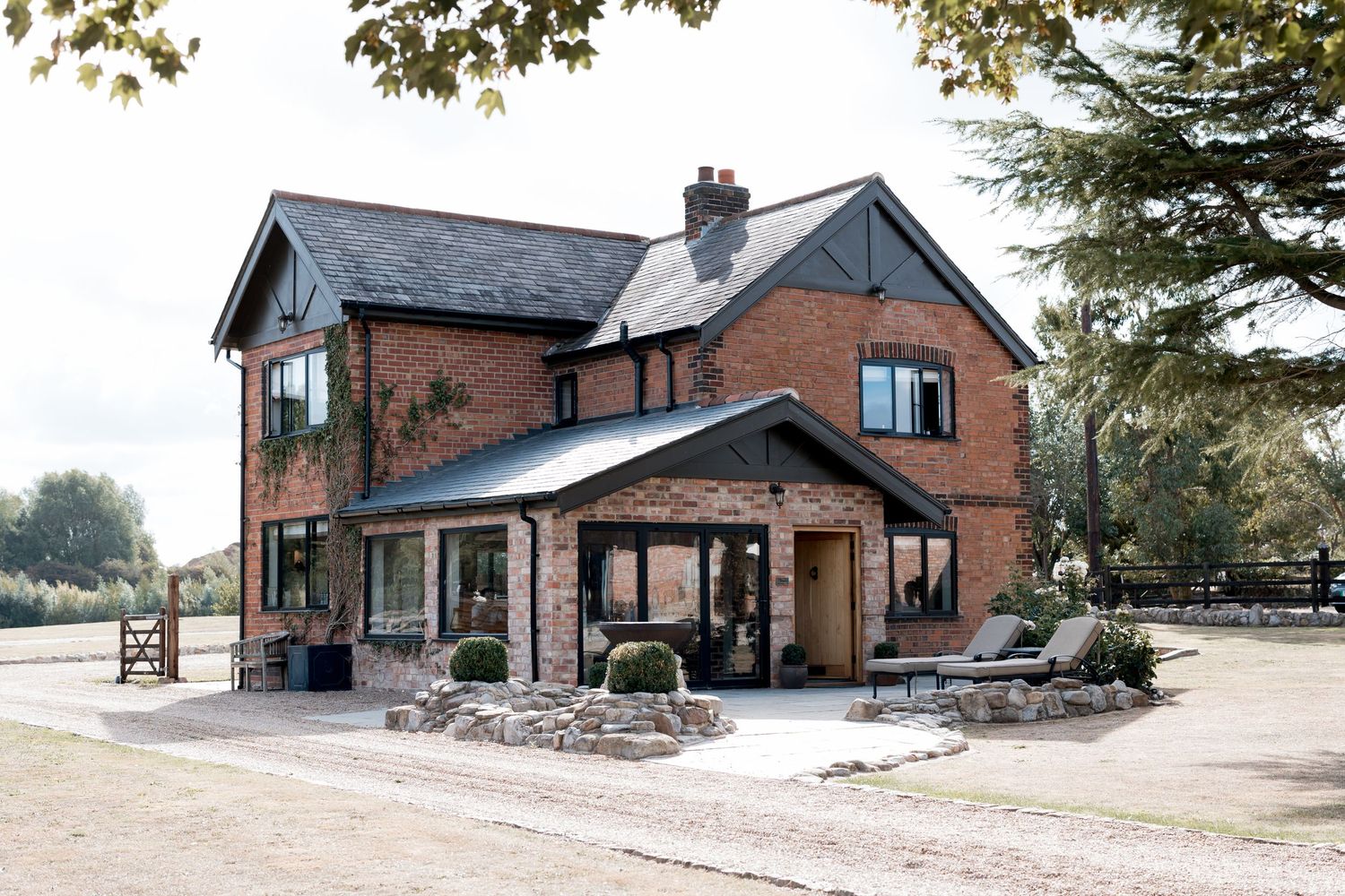 Rural brick wedding venue buildings surrounded by landscaped grounds.