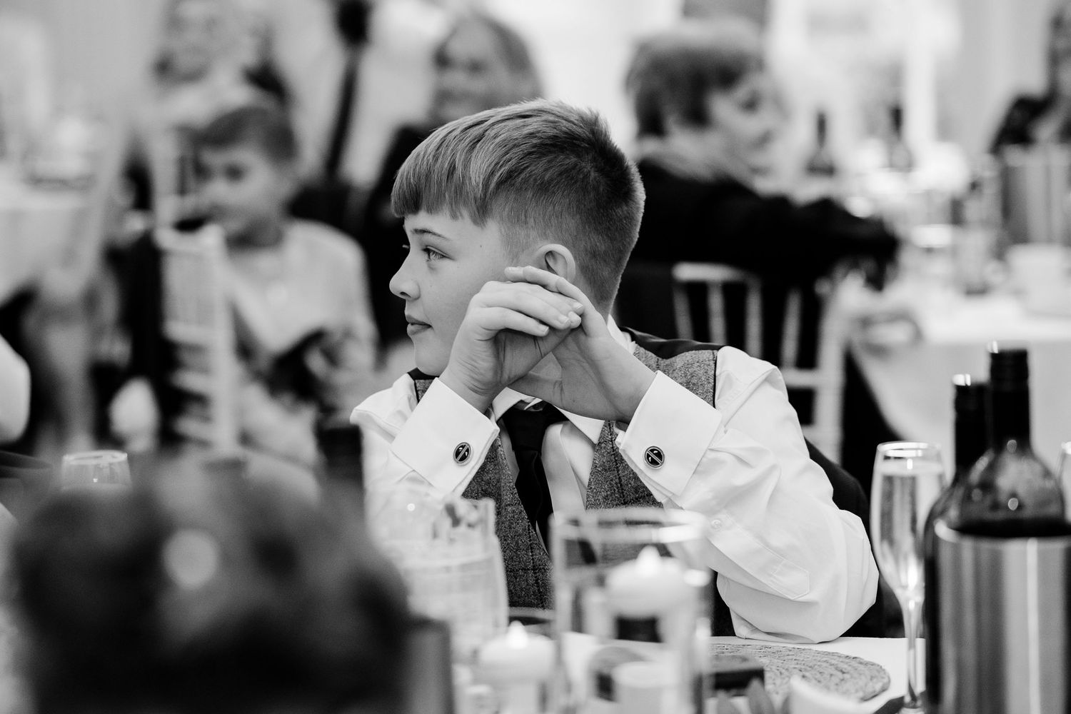 Wedding guests enjoying a celebratory meal at elegantly set reception tables.