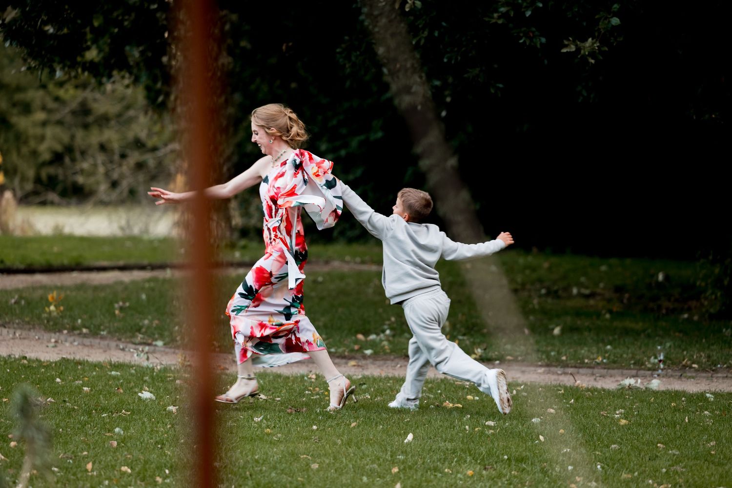 Children playing and running on a grassy lawn during an outdoor event.