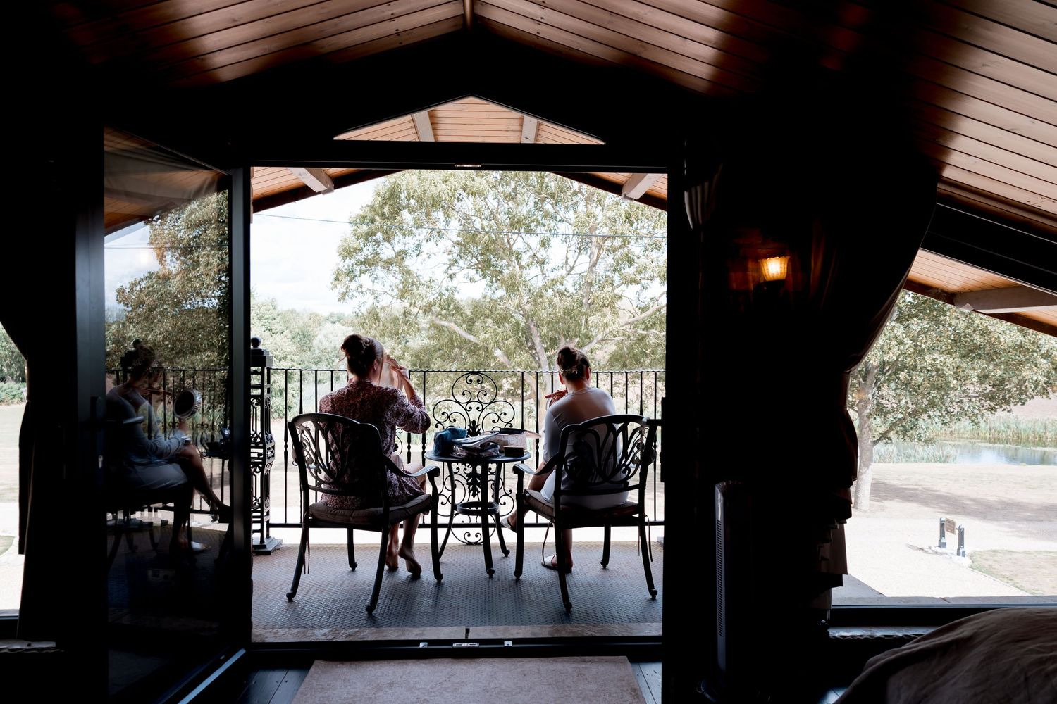 Rustic covered outdoor venue with wooden beams and natural lighting streaming through.