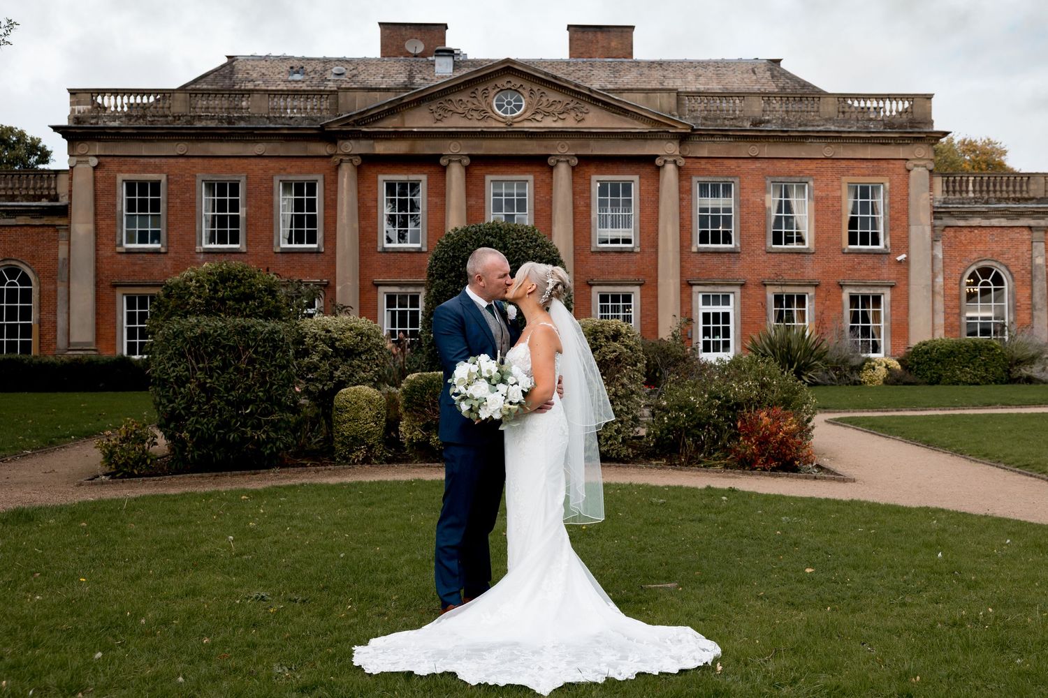 Wedding photos taken in front of a grand historic mansion with red brick facade.