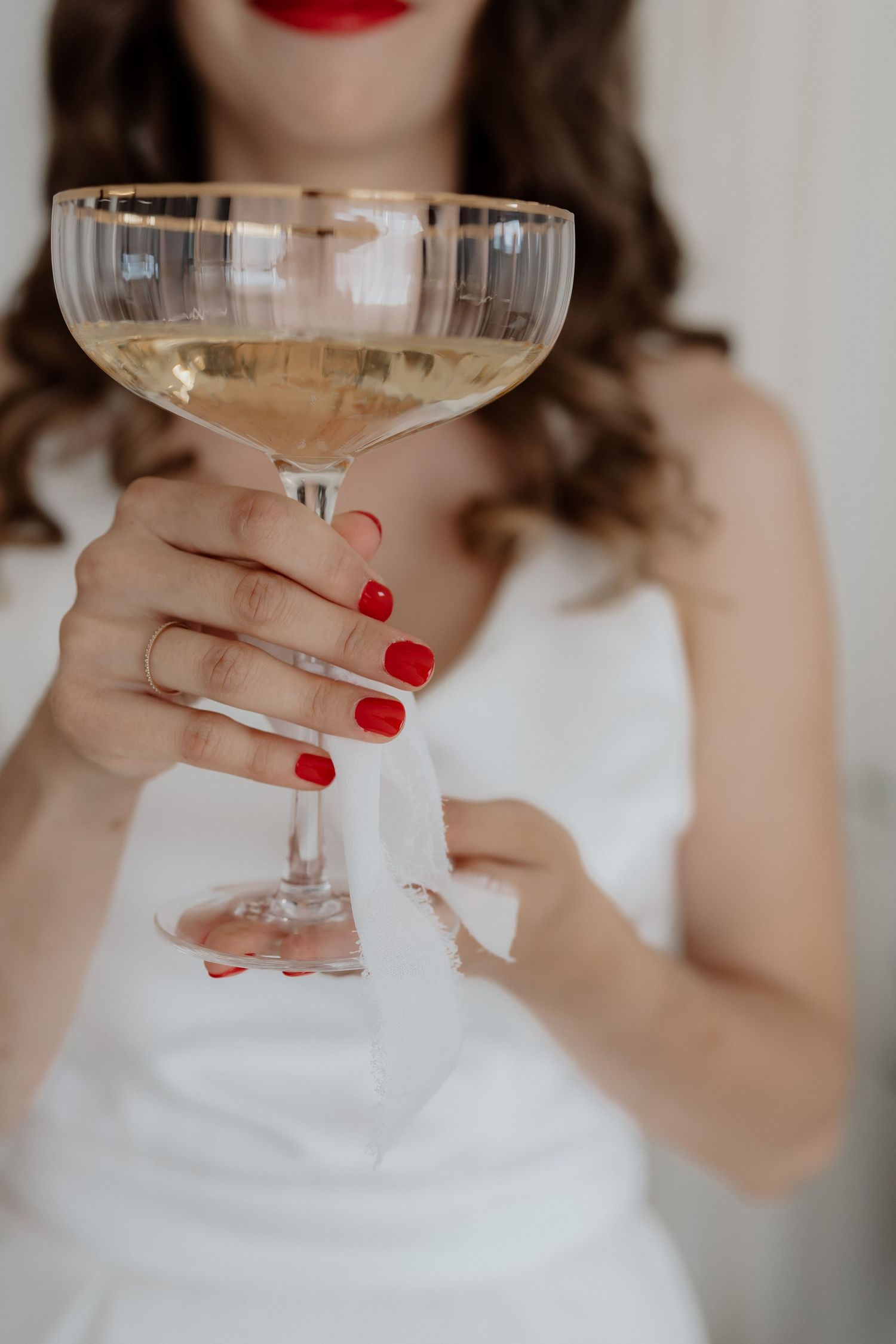 Braut mit Champagnerglas und roten Fingernägeln, Reportagefotografie Hochzeiten Graz und Steiermark