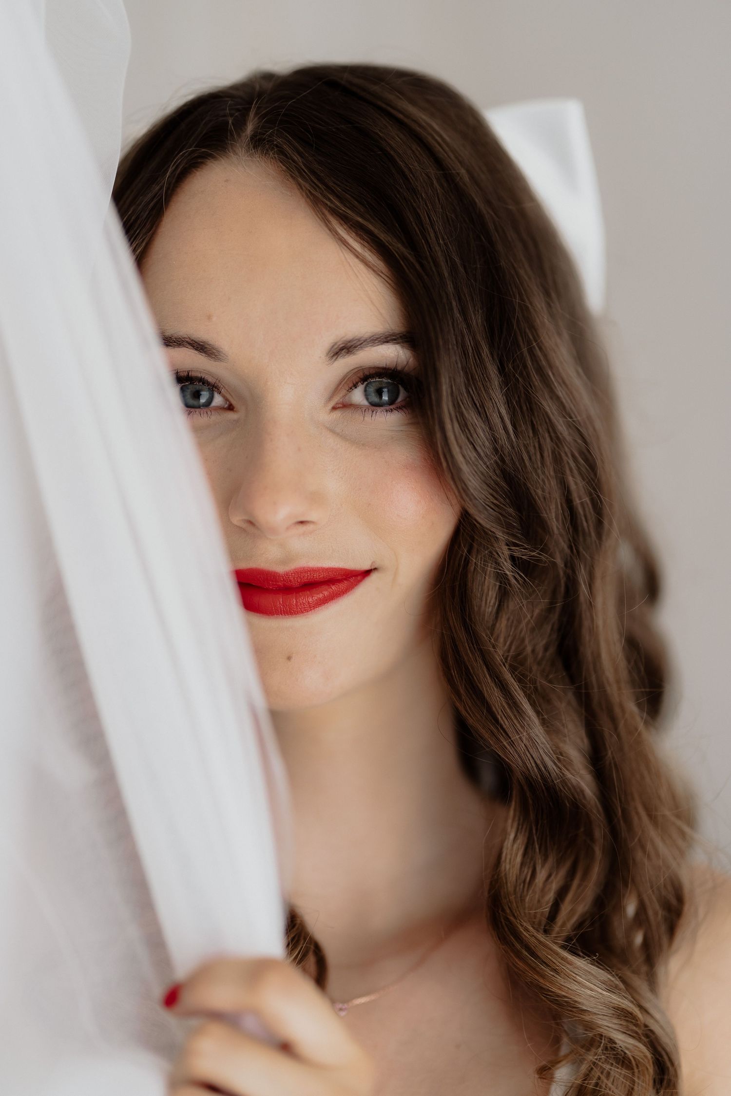 Braut mit roten Lippen und Schleier, Getting Ready und Make-up der Braut fotografiert von Hochzeitsfotografin Hutter Graz