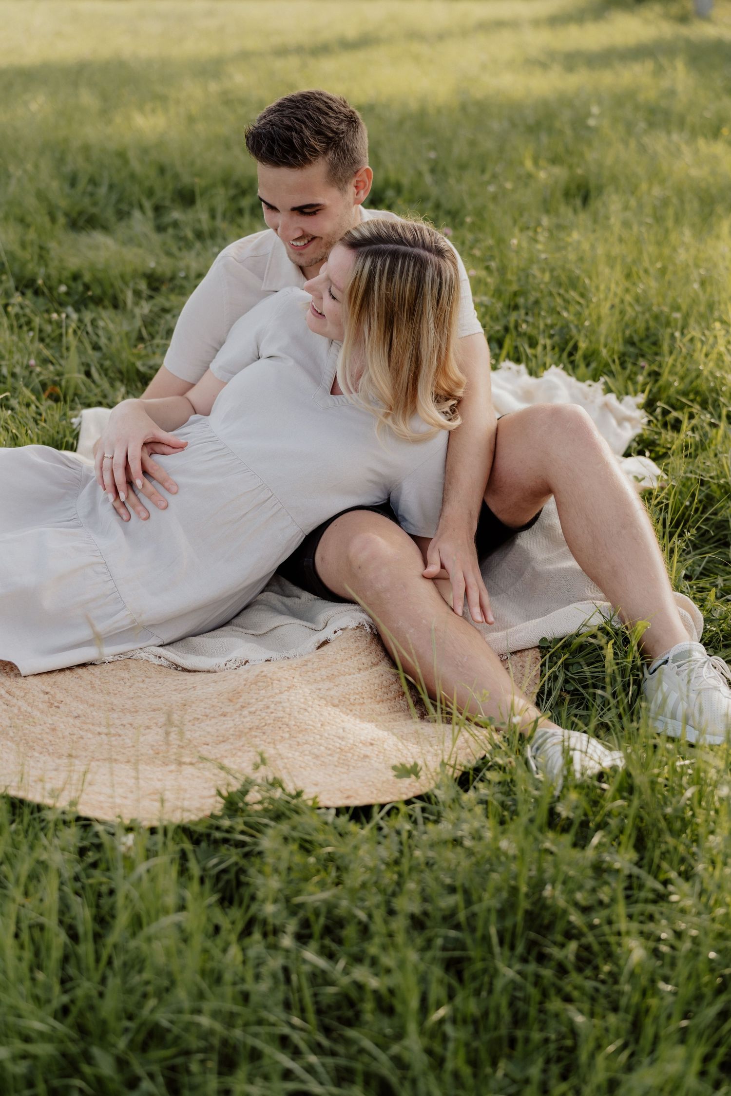 Pärchen in der Wiese Picknick, Babybauchfotos Steiermark, fotografiert von Stefanie Hutter