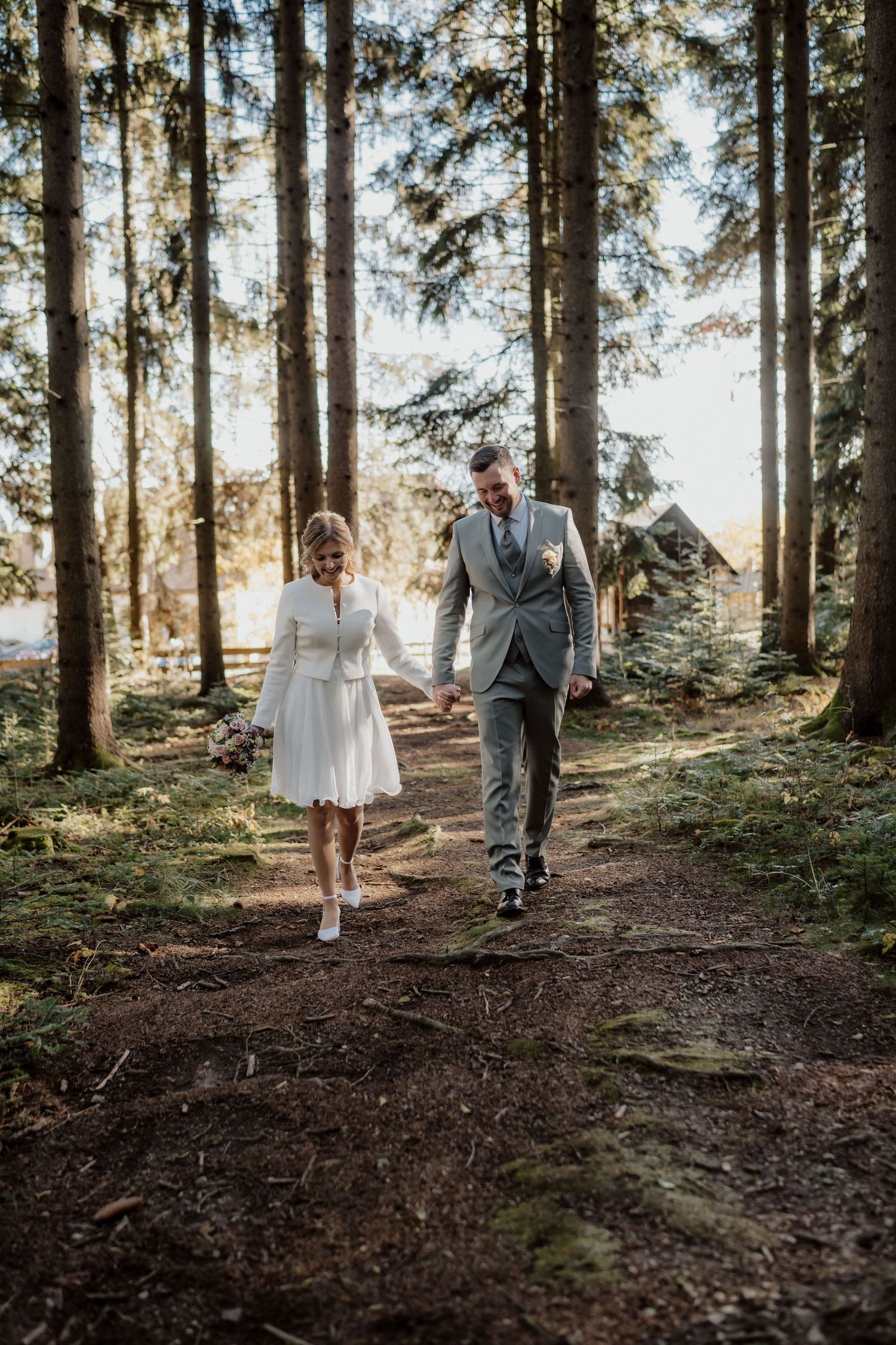 Hochzeitspaar am Weg durch den Wald in der Steiermark