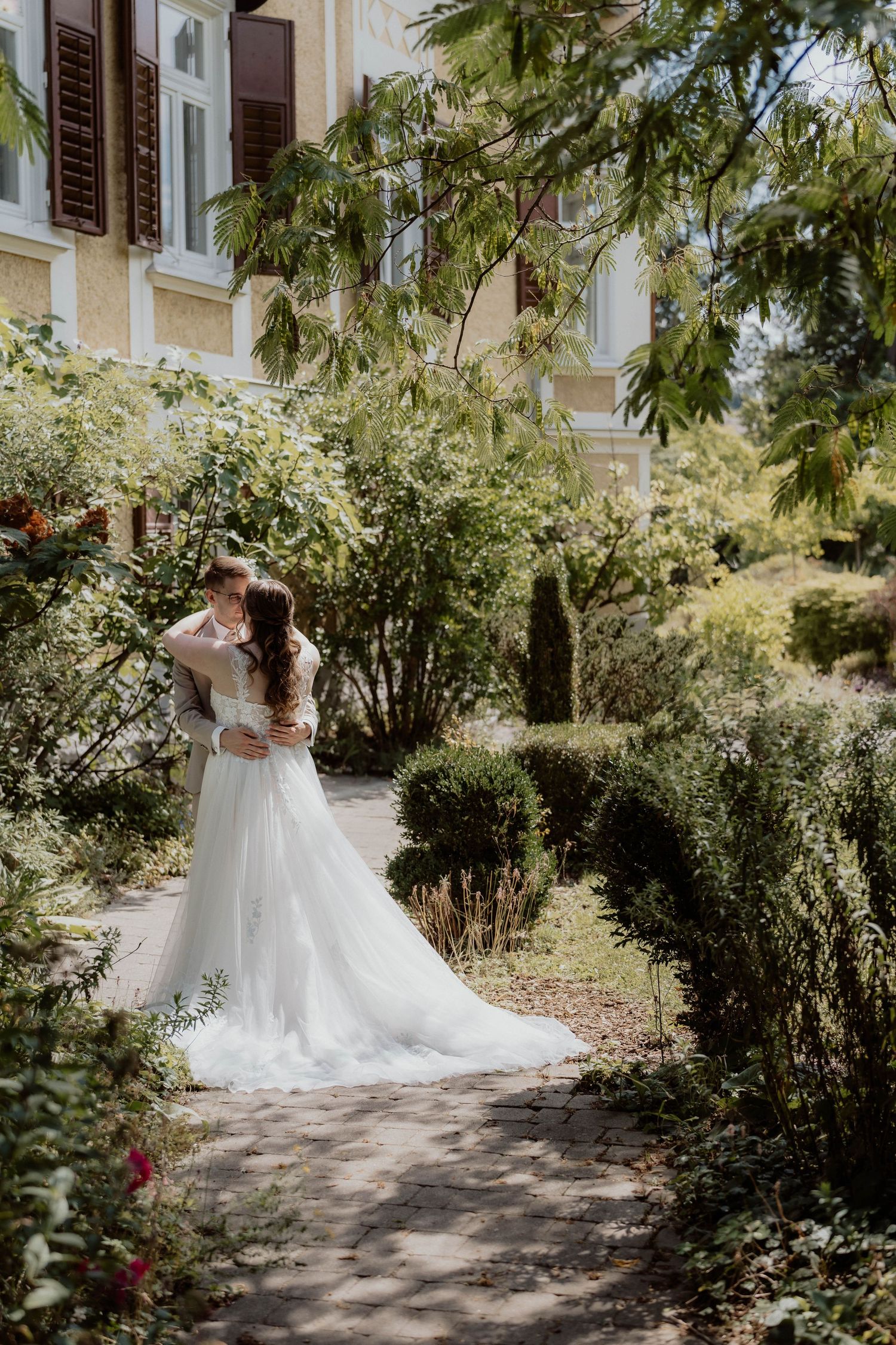 Brautpaarfoto im Park in Raaba, zärtliche Umarmung von Braut und Bräutigam, Hochzeitsfotograf Graz