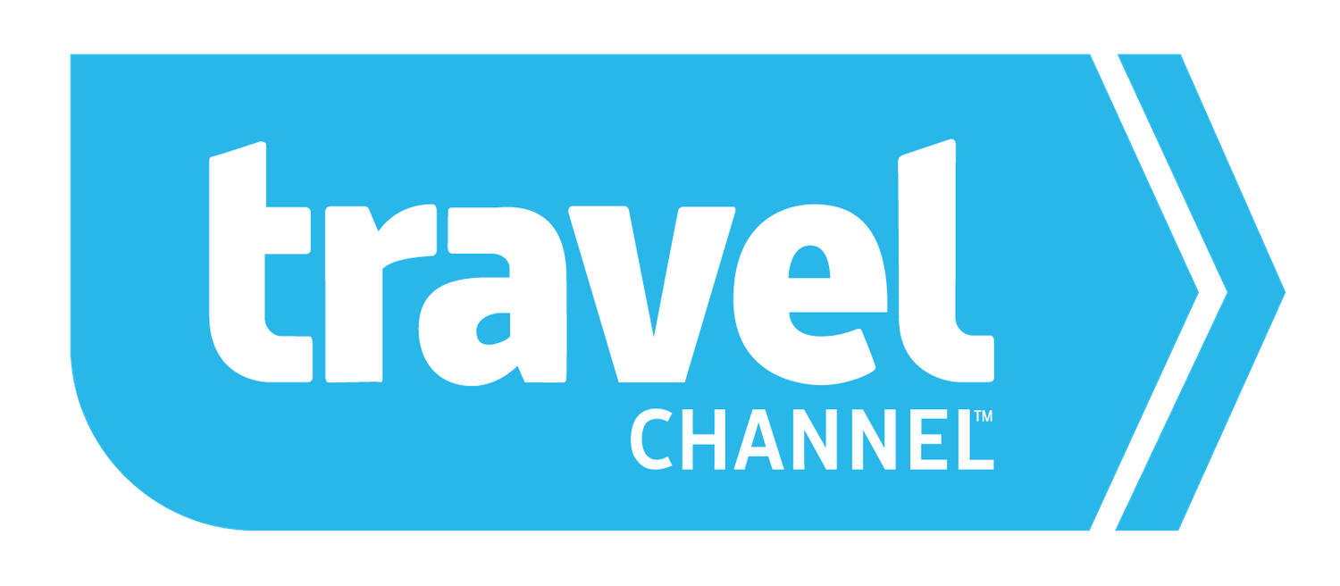 Travel Channel logo in white text against a bright blue arrow-shaped background.