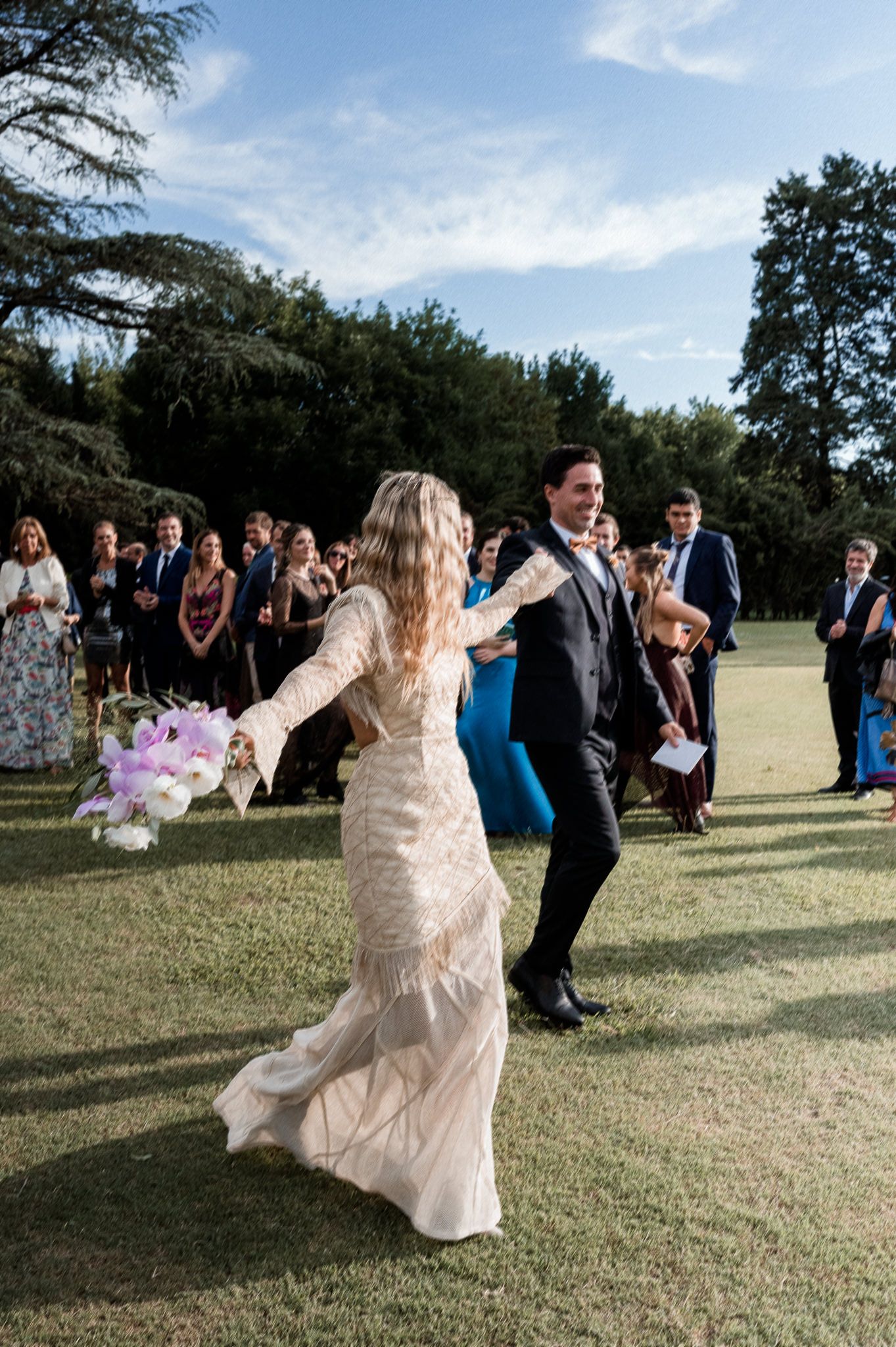 A series of photos showing a person in a flowing dress twirling and dancing on a grassy lawn at an outdoor event.