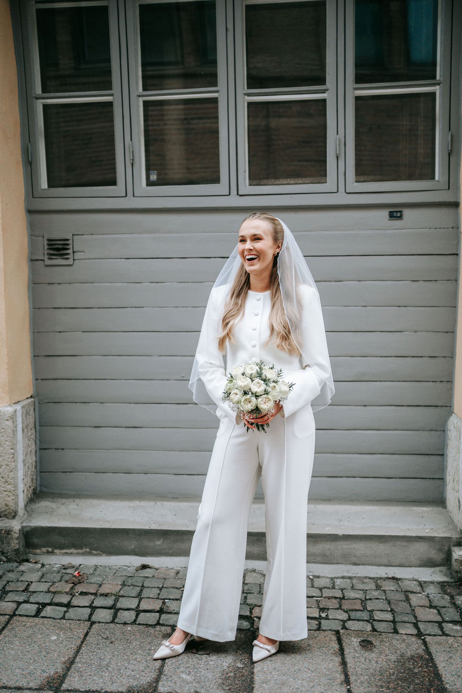 Brud håller en vit bukett utomhus i centrala Göteborg nära rådhuset, brudporträtt, fotografering bröllop rådhuset göteborg