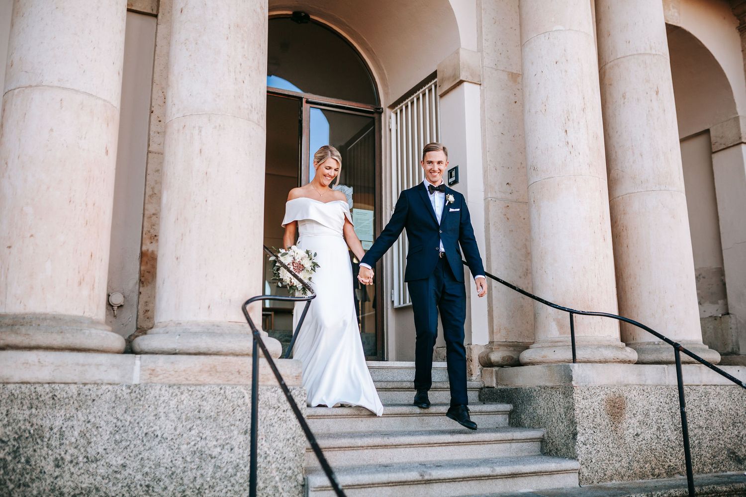 nygift kvinna och man går ut ur rådhuset i göteborg, för att mötas av gratulationer av gäster, bröllopsfotografering