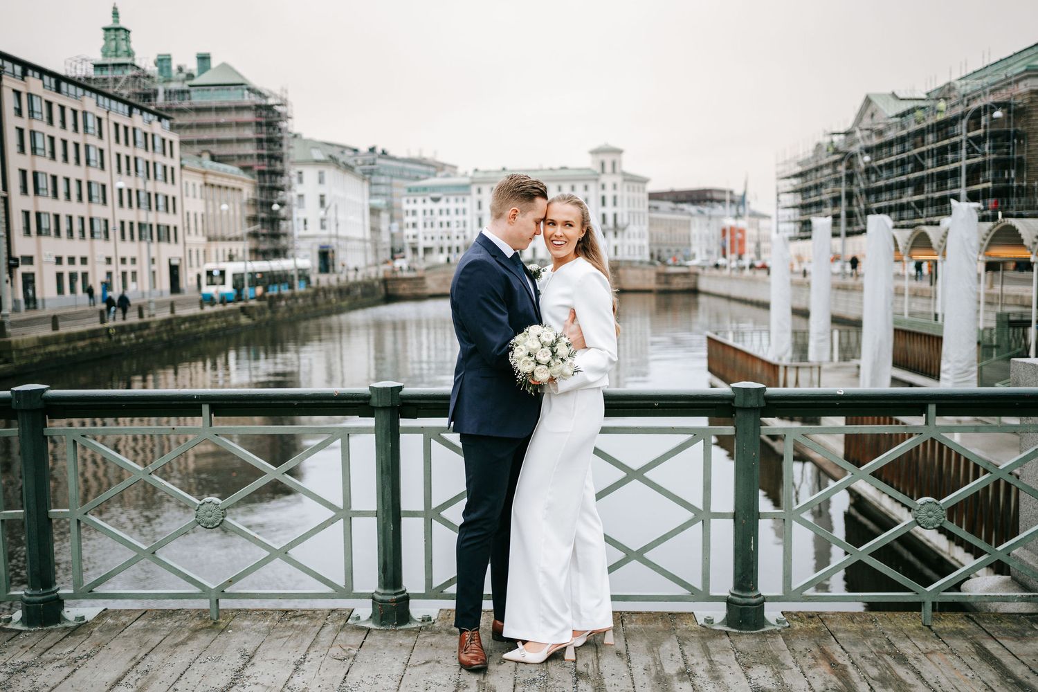 Intimt porträtt av brudpar på tyska bron nära rådhuset i Göteborg under bröllopsdag med kanalen bakom, stadsmiljö, göteborg, fotografering