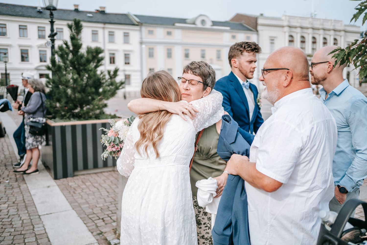 brud får en känslosam kram av sin mamma utanför rådhuset i göteborg efter vigsel, bröllopsfotografering  Gustaf Adolfs torg, gratulationer
