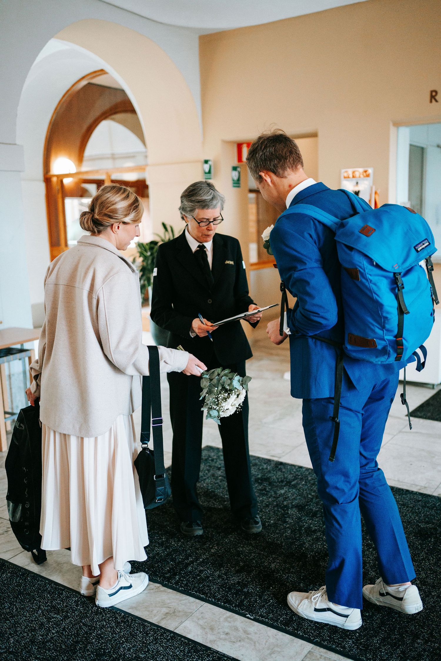 brudpar anmäler sig till vakten inne i rådhuset i göteborg vid ankomst, bröllopsfotografering