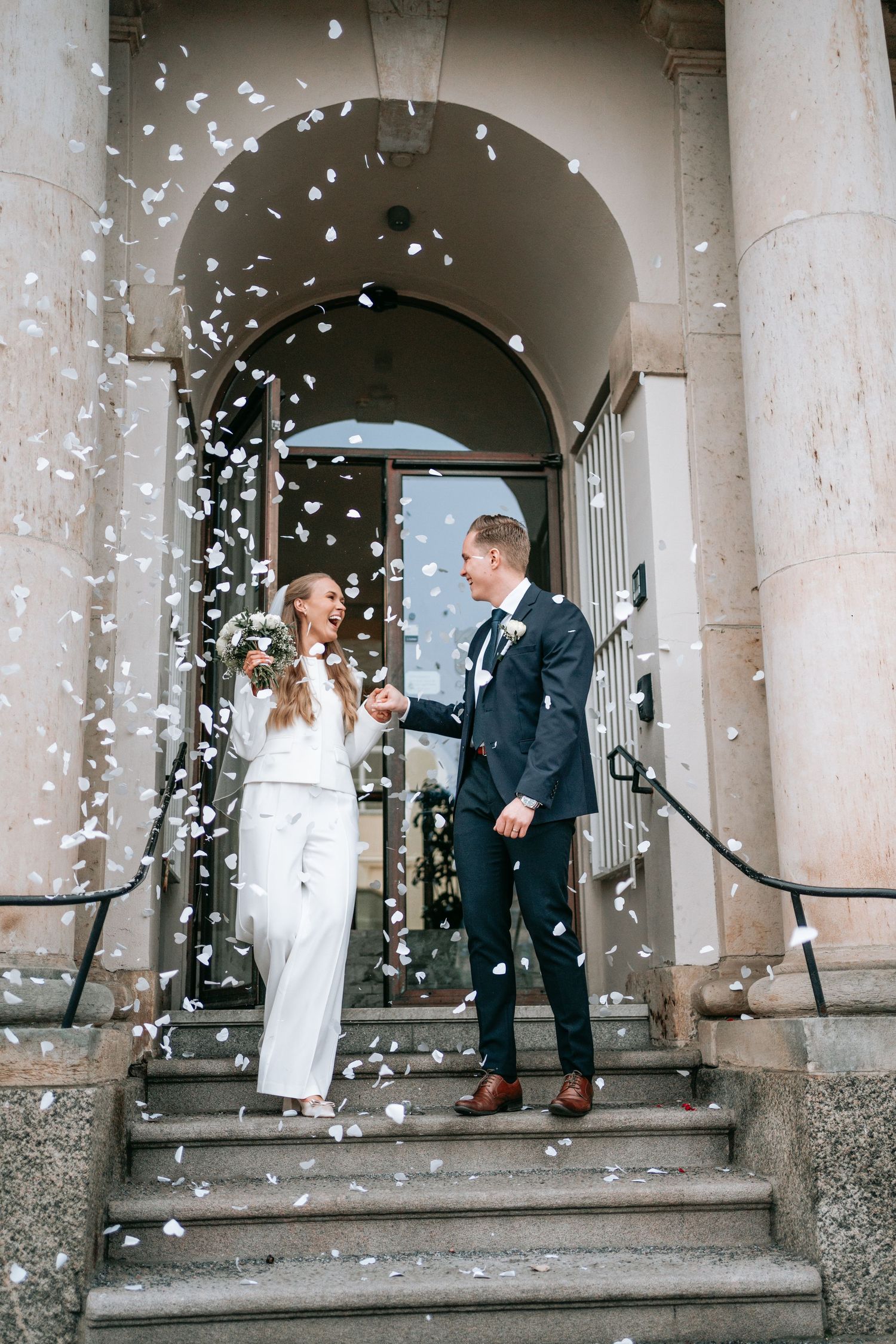 brudpar som kommer ut på trappan utanför rådhuset i göteborg med konfetti som regnar ner över dom, bröllopsfotografering