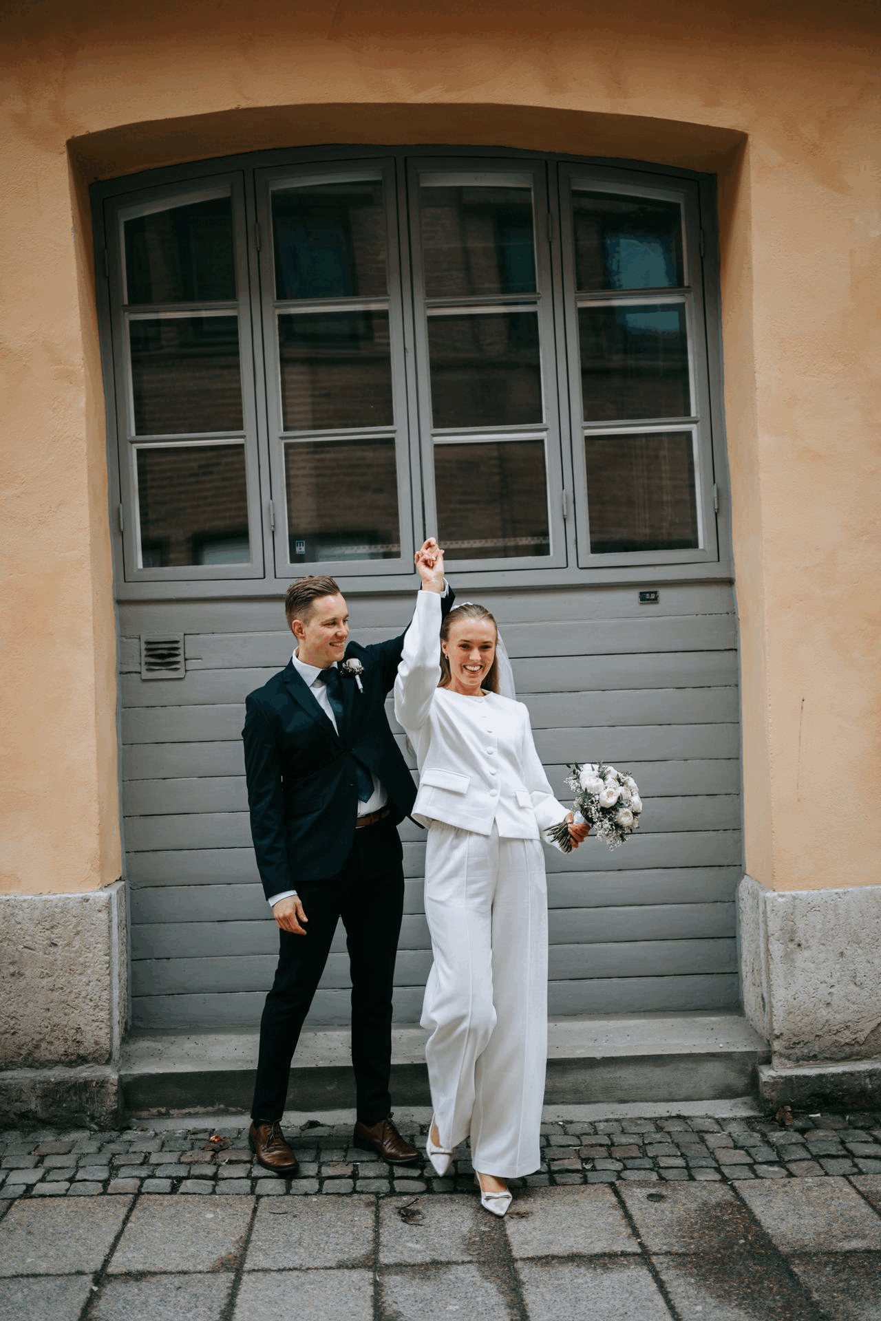 brudpar som dansar tillsammans framför en grå dörr vid kronhusbodarna i göteborg, bröllopsfotografering, GIF