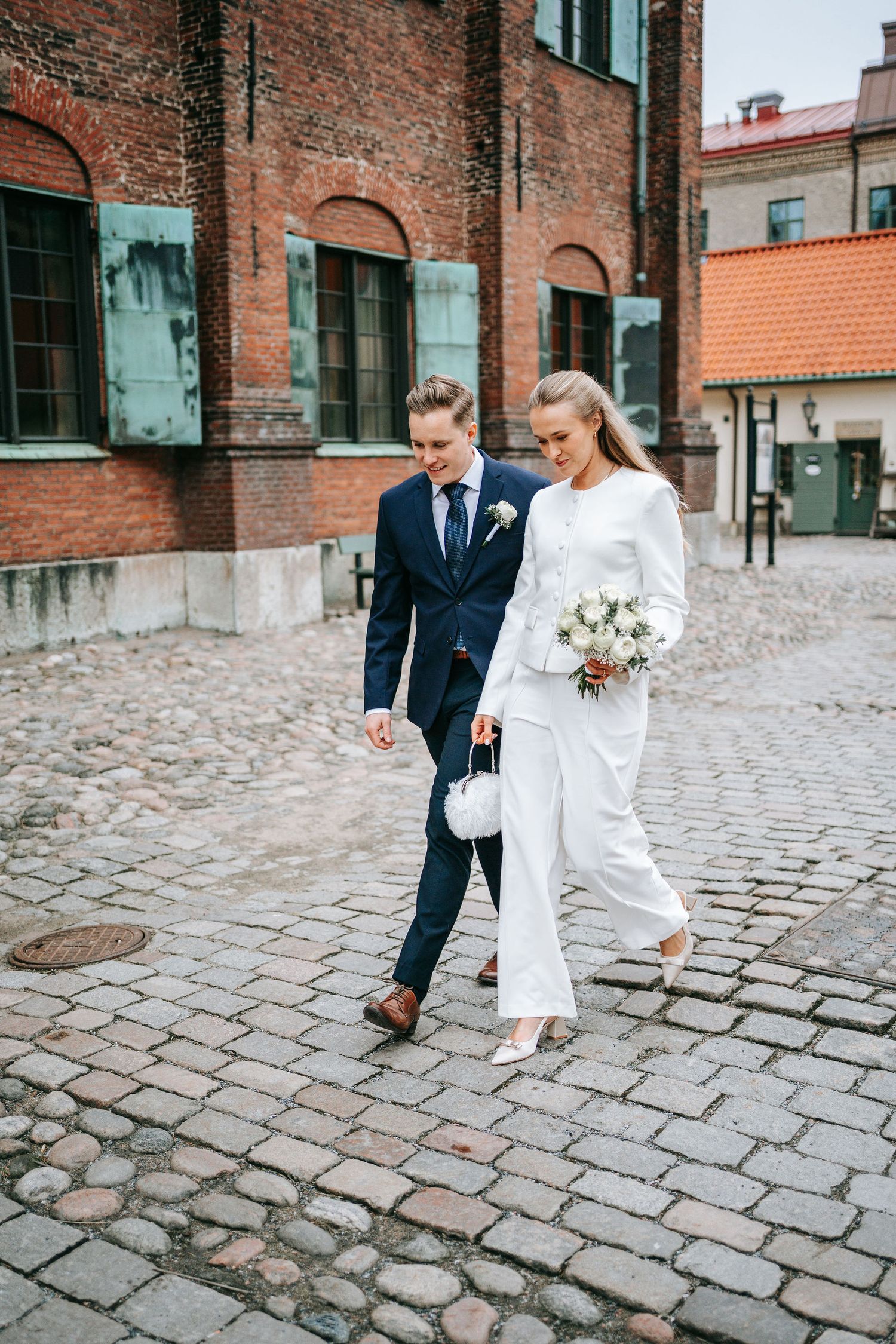 Brudpar promenerar tillsammans nära rådhuset i Göteborg innan vigsel, bröllopsfotografering