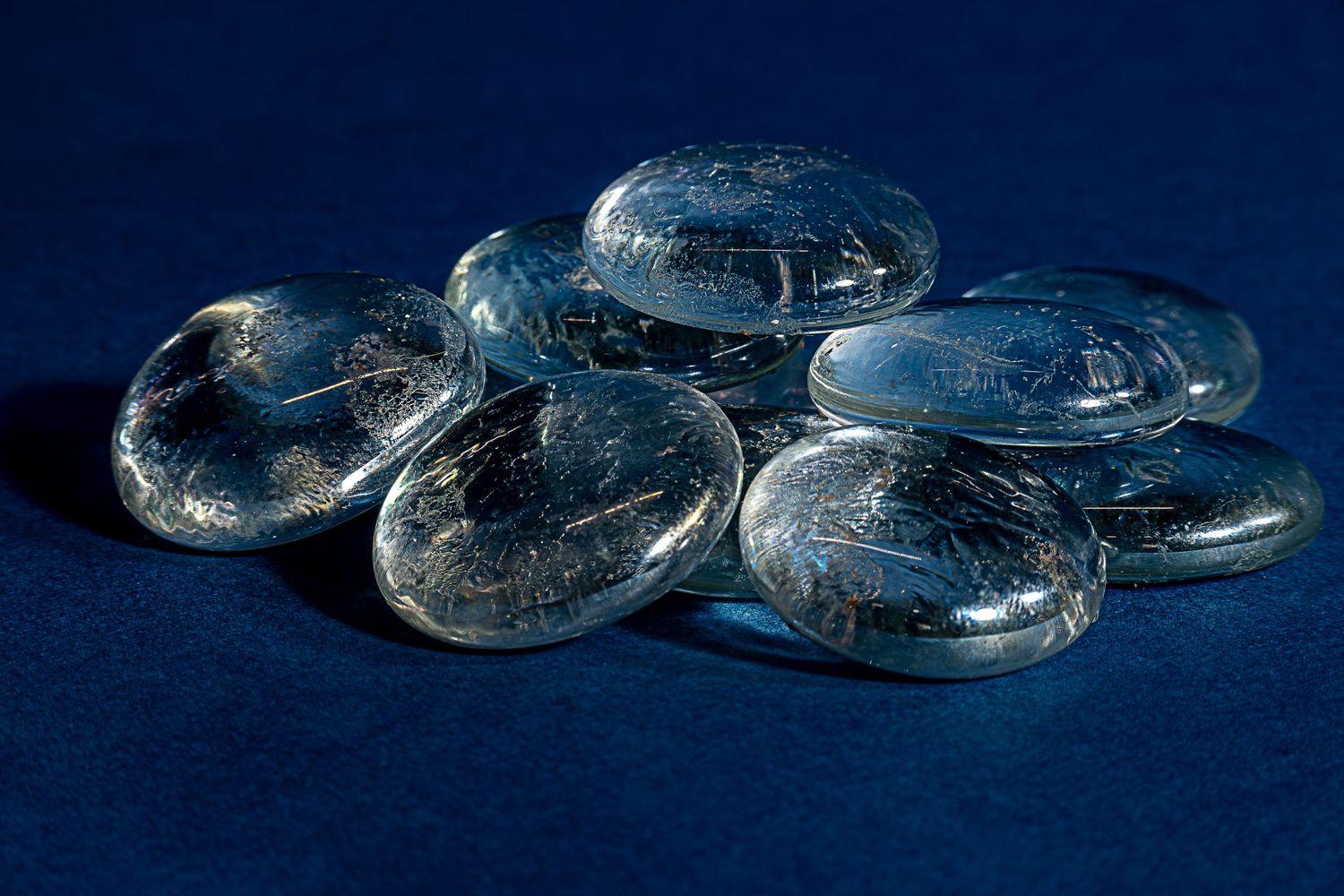 Image of clear pebbles on a blue background, meant to be products that a company will be selling on their website.