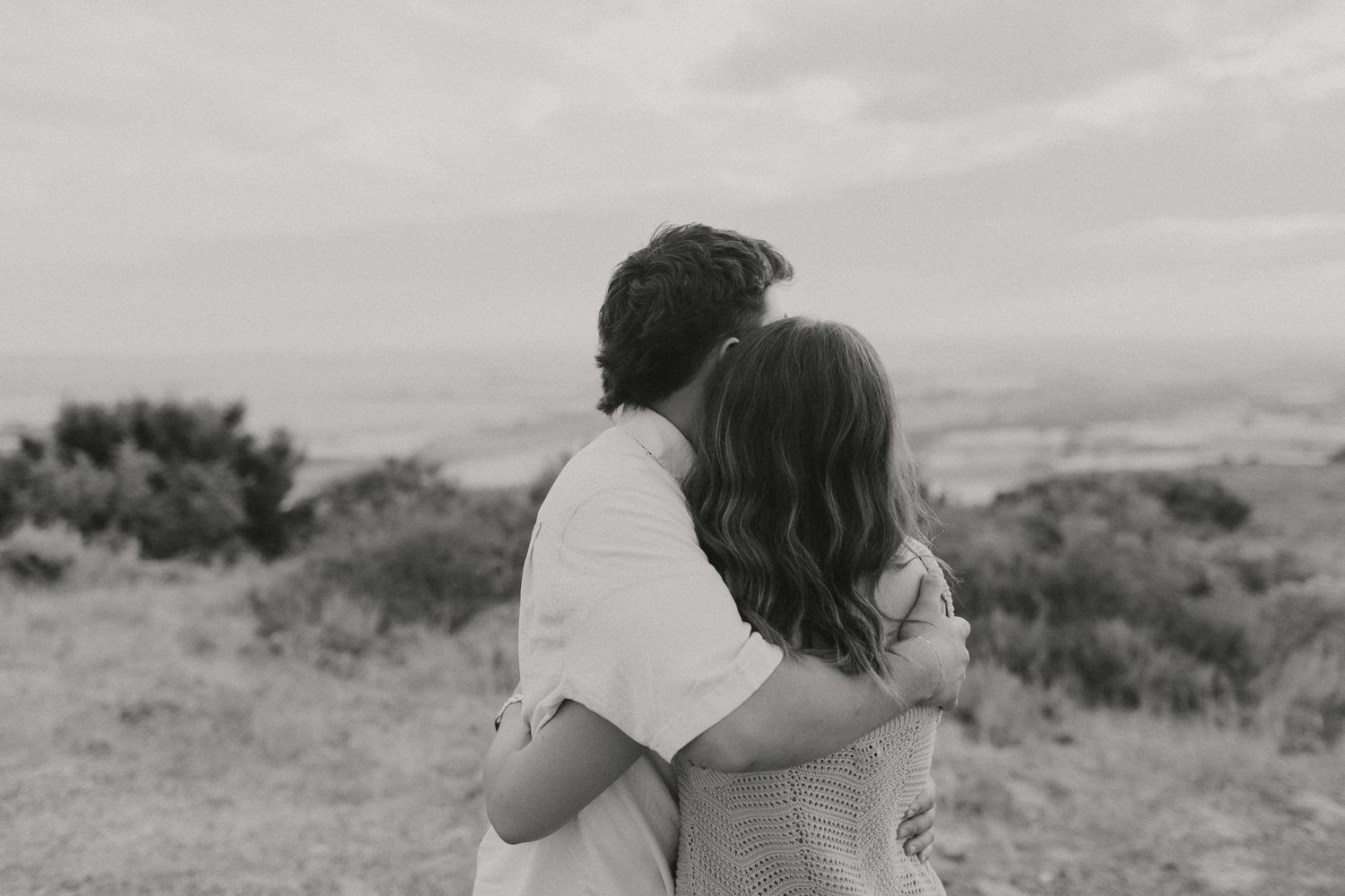 Black and white landscape photos showing intimate moments between two people outdoors.
