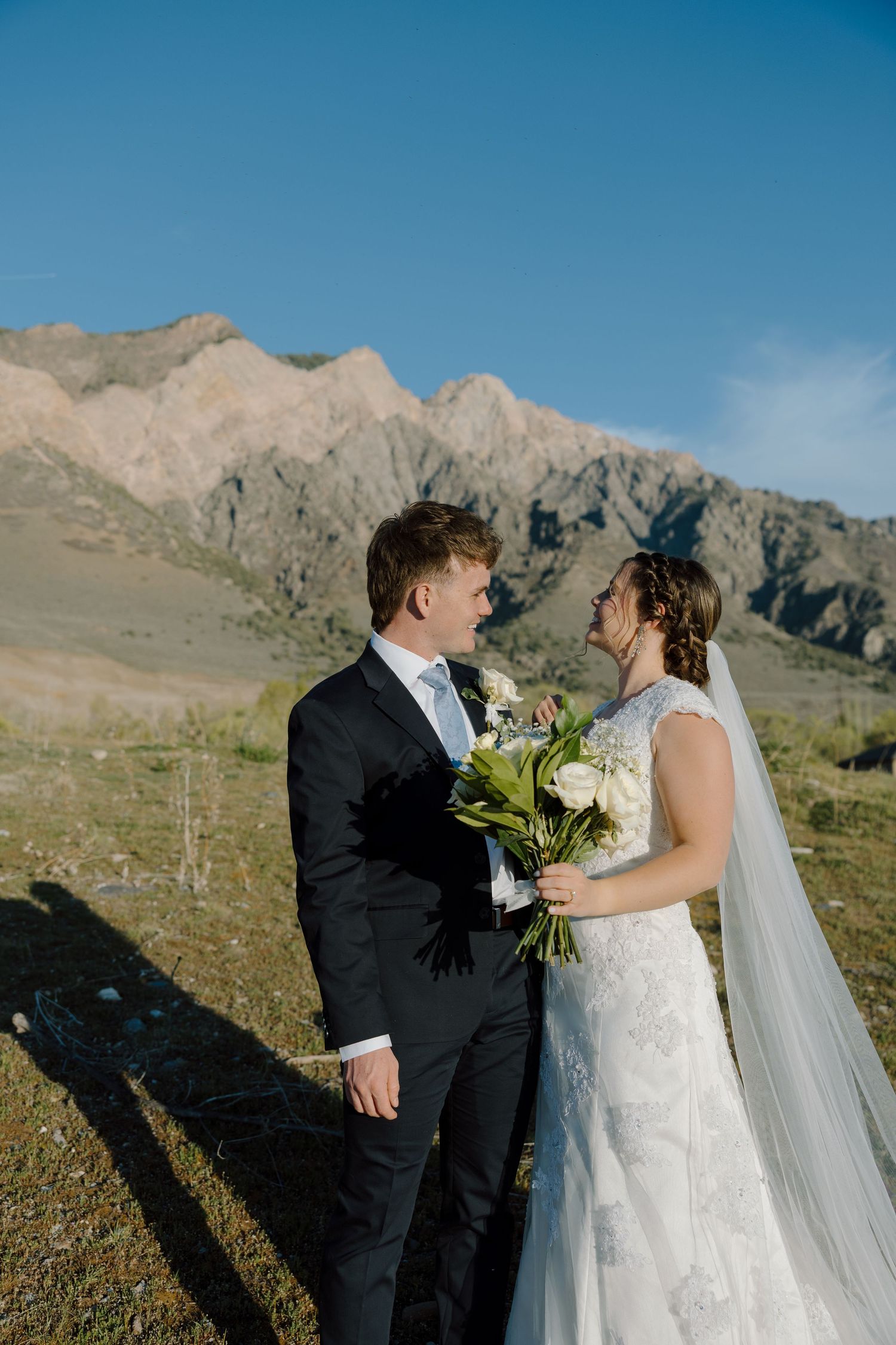 Bride and groom share an intimate moment with stunning rocky mountain backdrop on their wedding day.