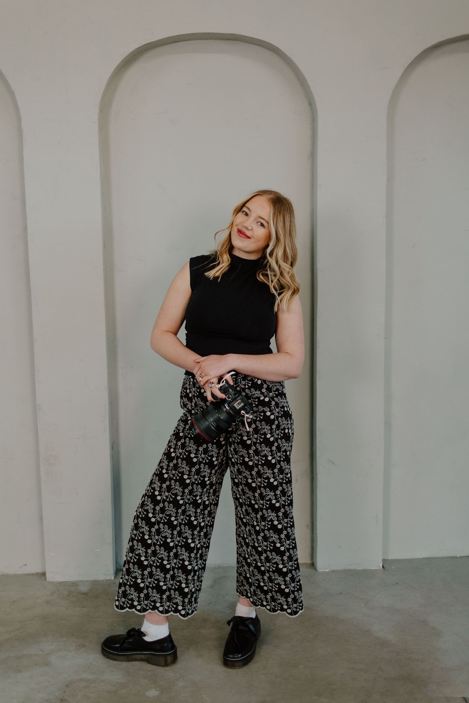 Fashion poses demonstrated in a modern studio with architectural arches.