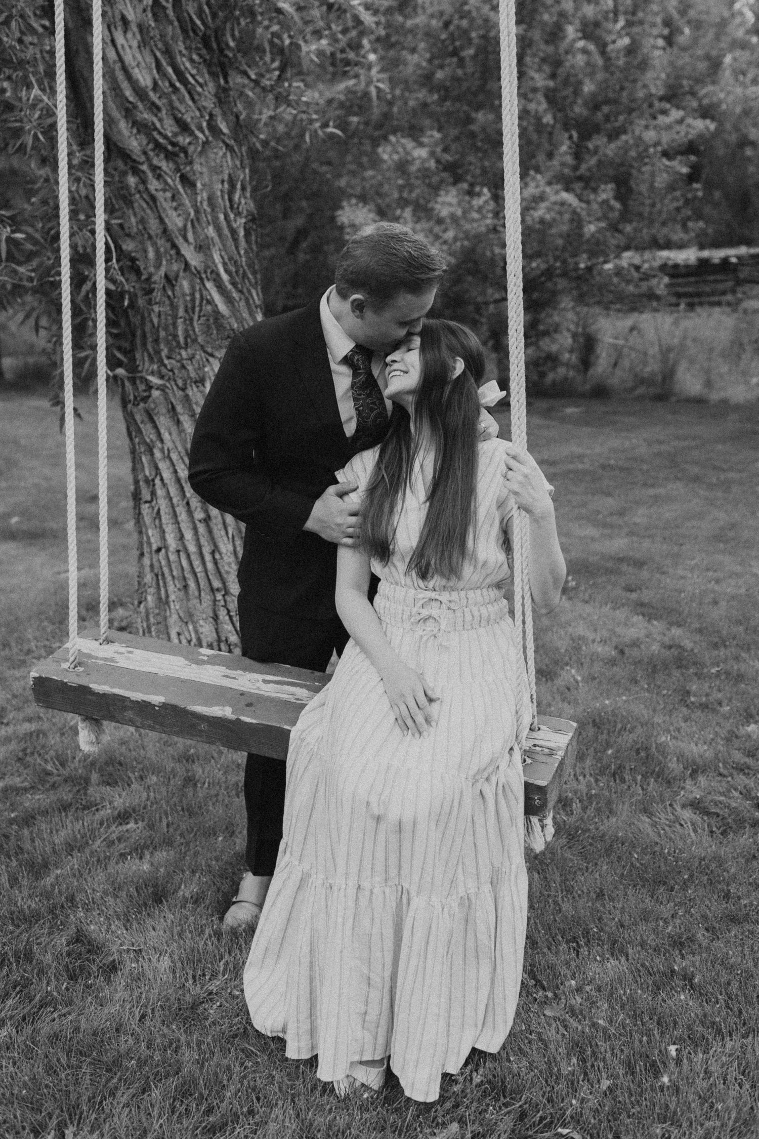 Black and white series of romantic dance poses near a tree in a garden setting.