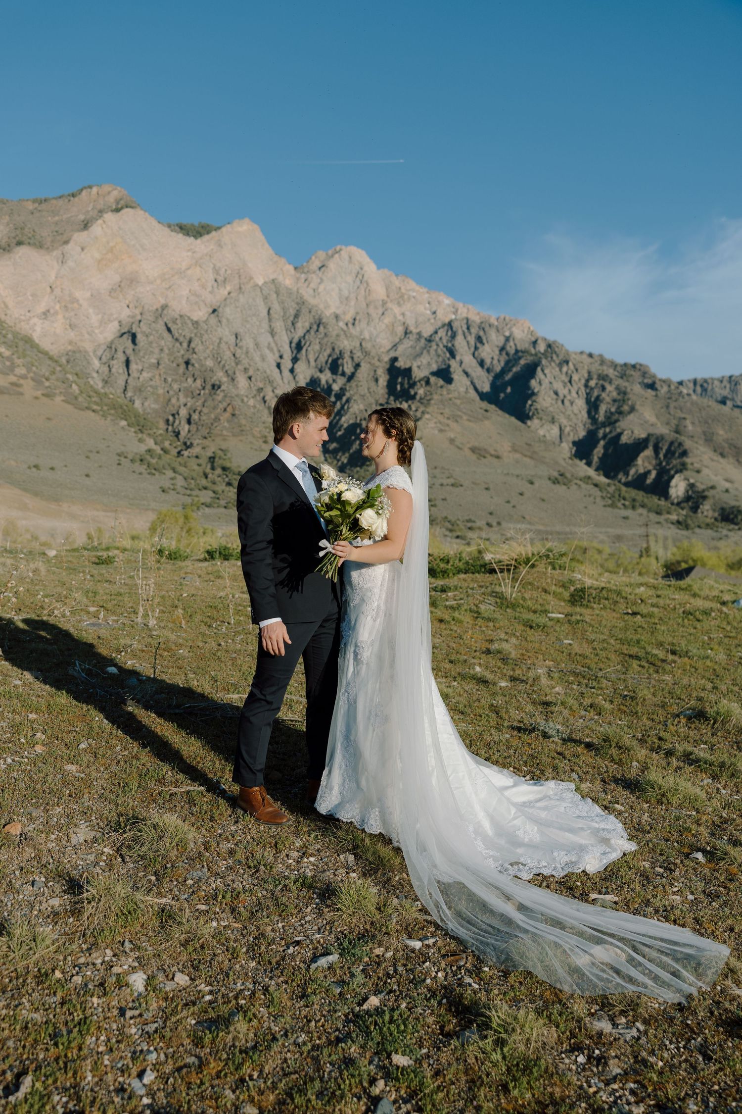 Bride and groom sharing a romantic moment in front of stunning mountain scenery.